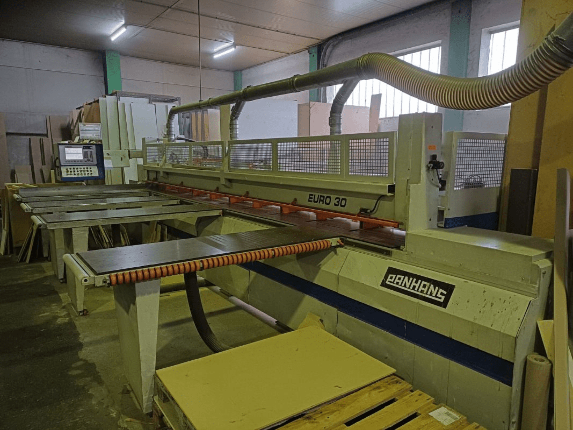 A PANHANS EURO 30 lemezfűrész előlapja a kezelőpanellel, a vágóasztallal és a porelszívó tömlővel műhelyben.