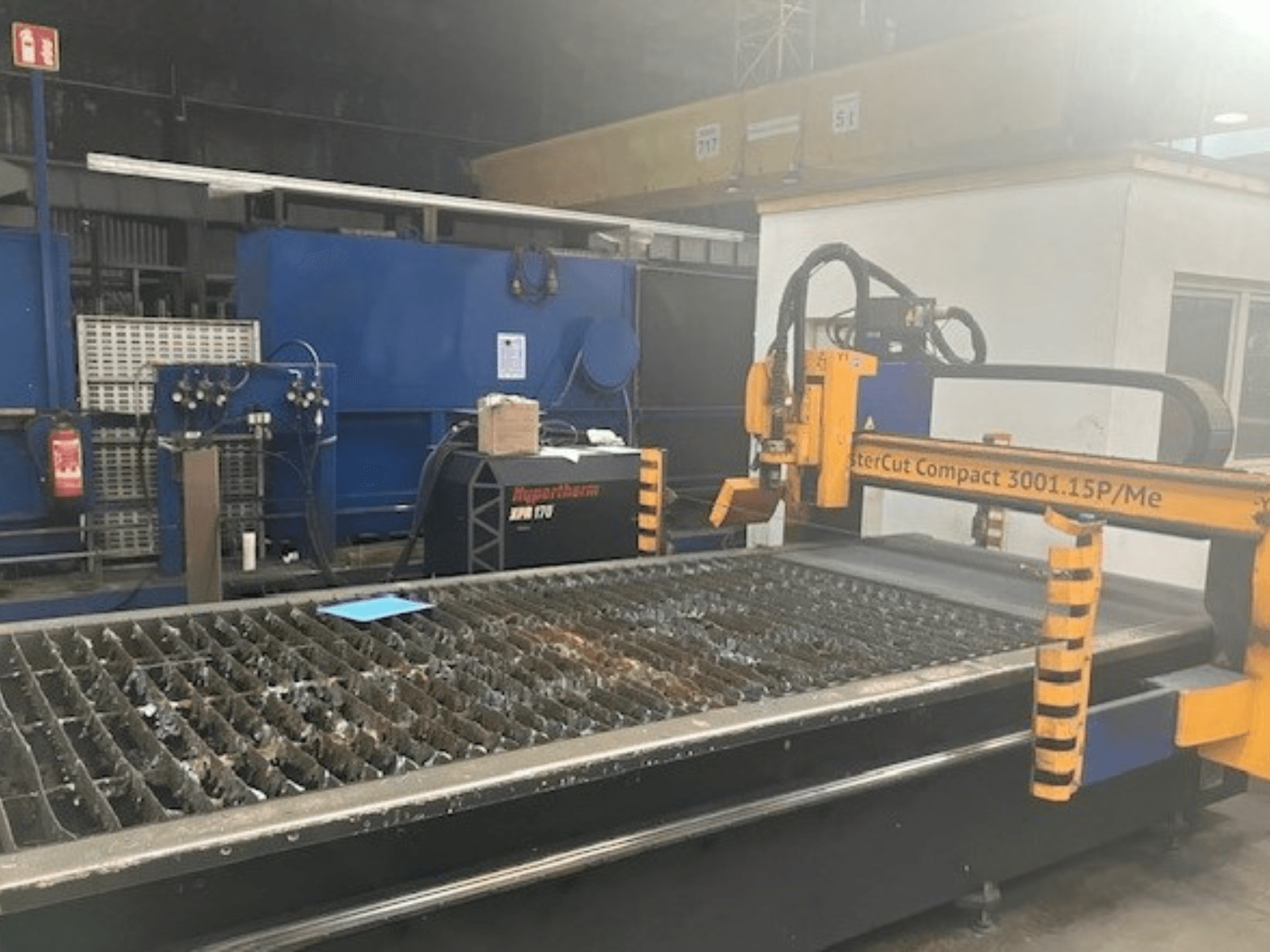 Hypertherm MasterCut Compact 3001.15P/Me plazmavágó gép oldalnézetben, a vágóasztal és a vezérlőpanel látható.