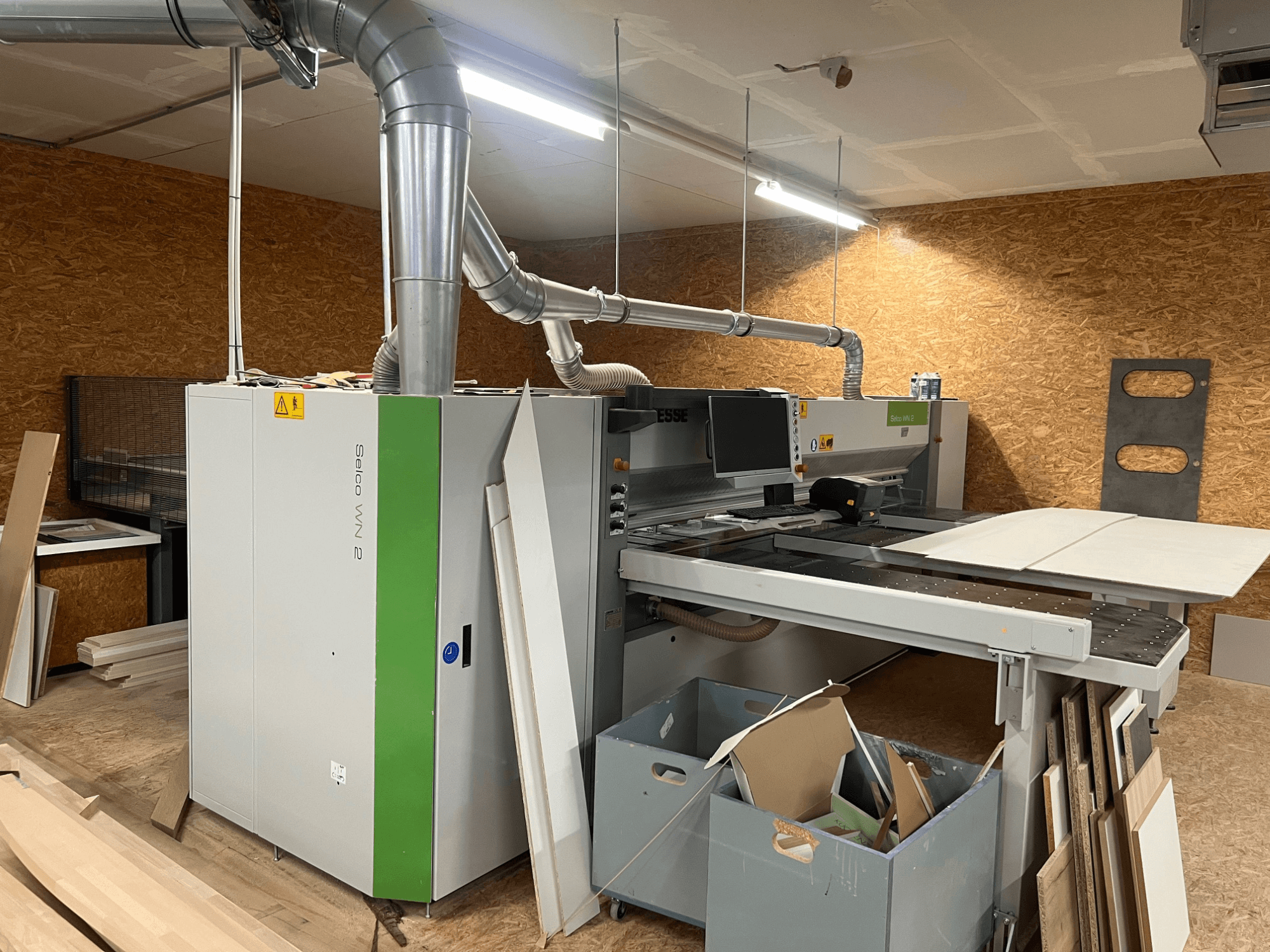 BIESSE Selco WN 2 lemezfűrész egy műhelyben, nagy vágóasztallal és porelszívó rendszerrel, oldalnézet.