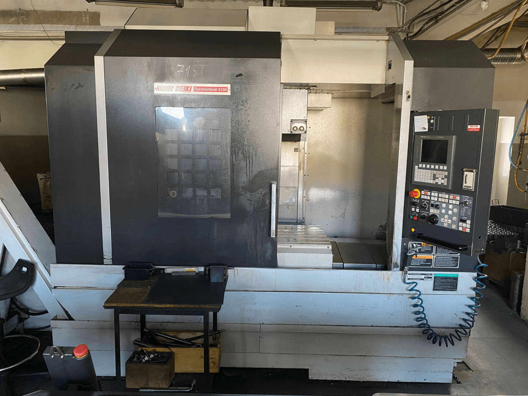 A MORI SEIKI DuraVertical 5100 elölnézetből, a kezelőpanellel, a munkaterülettel és a gép részleteivel.