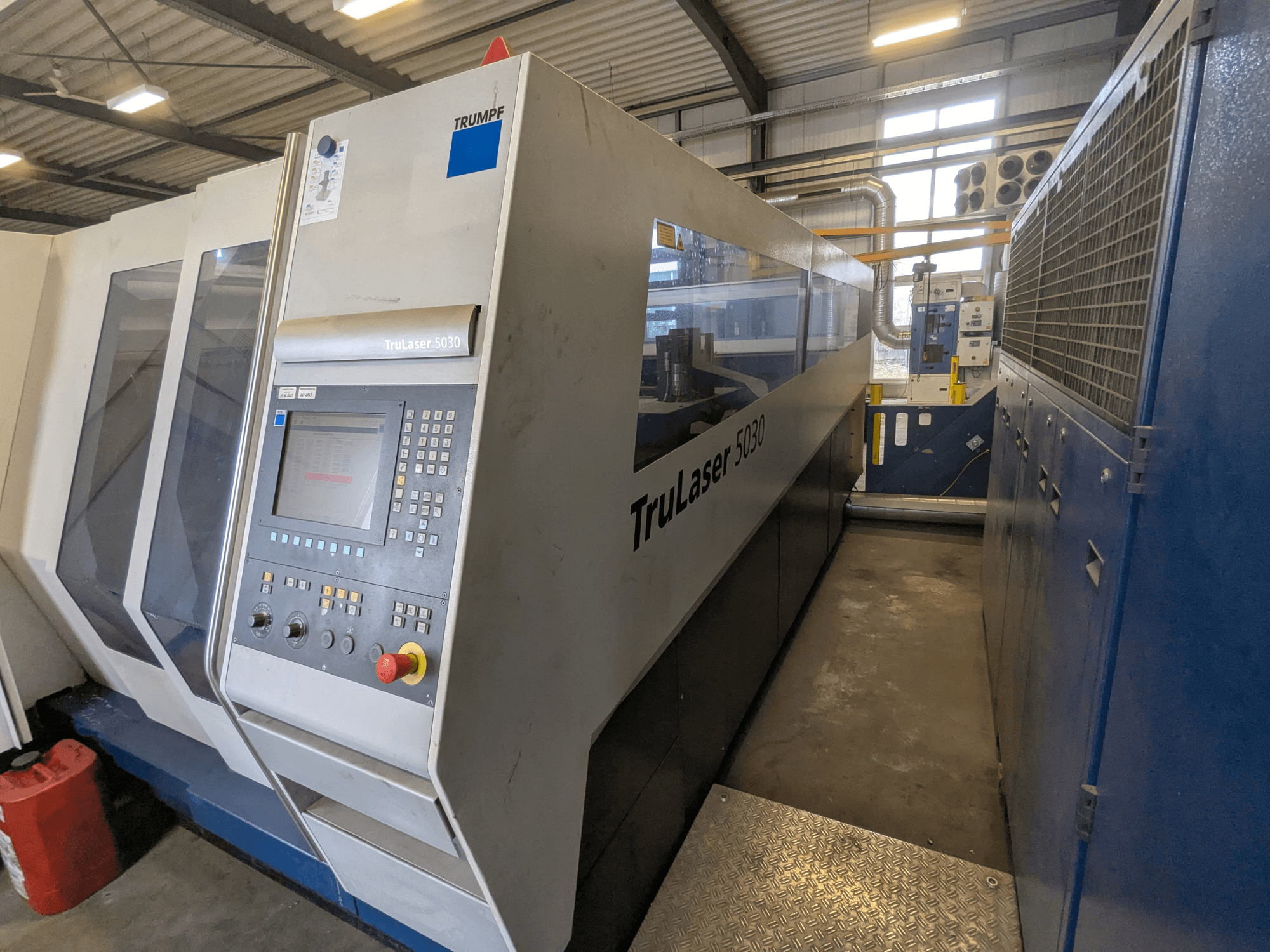TRUMPF TruLaser 5030 CO2 lézervágó gép, előlnézetben a vezérlőpanel és a karcsú kialakítás, ipari környezetben.