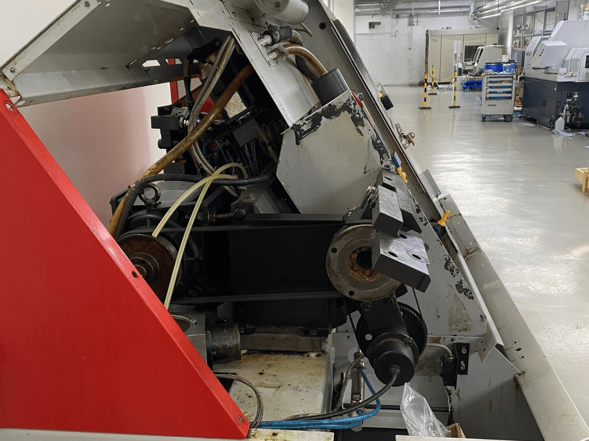 EMCO Emcoturn 325 vízszintes esztergagép, oldalnézetben a meghajtási alkatrészek és a hidraulika ipari környezetben.