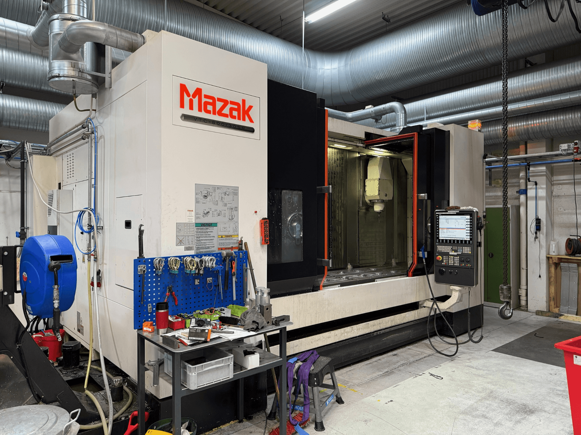 Mazak CNC-gép elölnézetből, a kezelőszervek, a szerszámok és a munkaterület a megmunkálási környezetben.