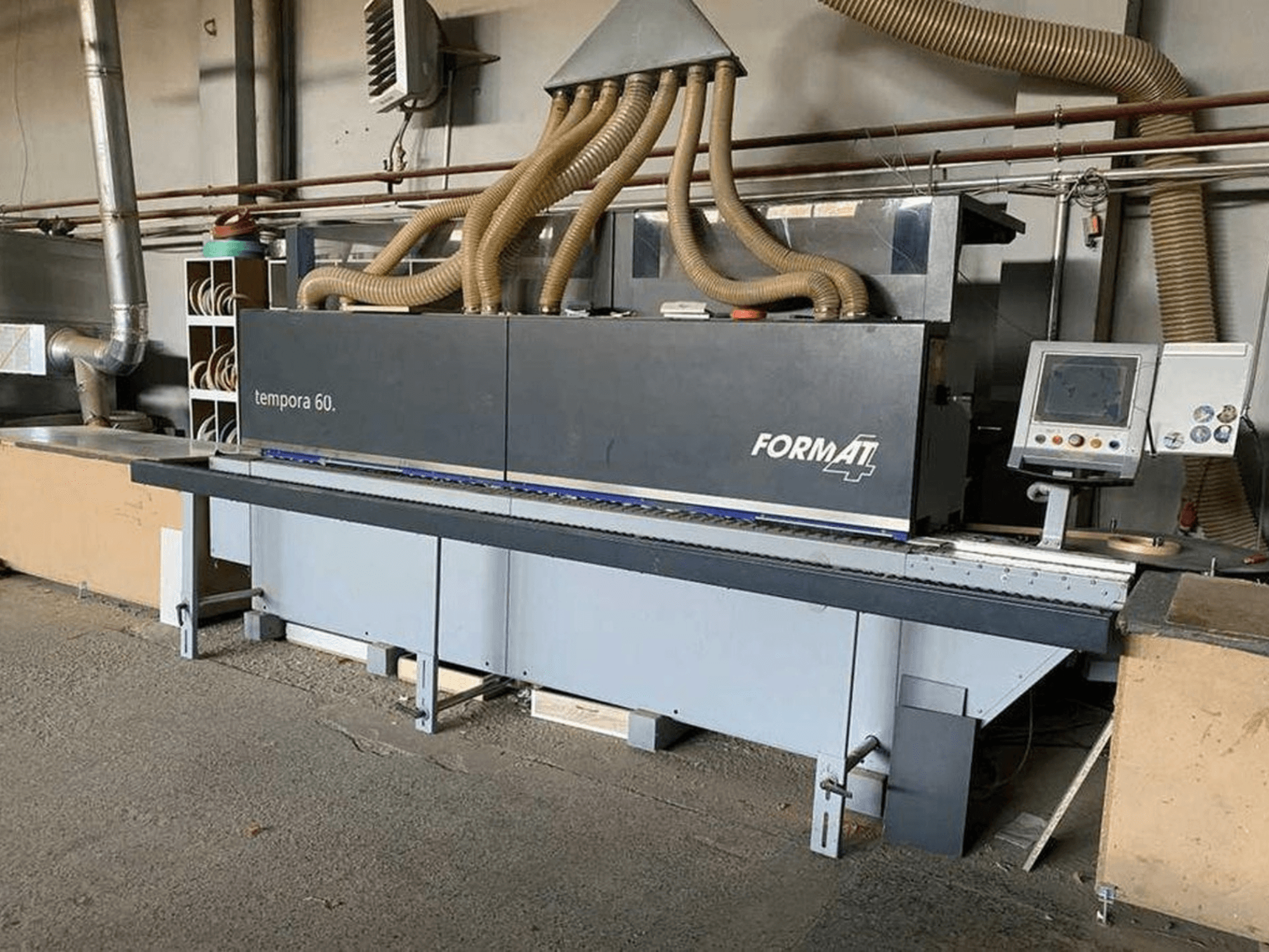 FORMAT4 Tempora 60 szegélyezőgép oldalnézetben, több tömlővel, gombokkal és képernyővel ellátott kezelőpanellel.