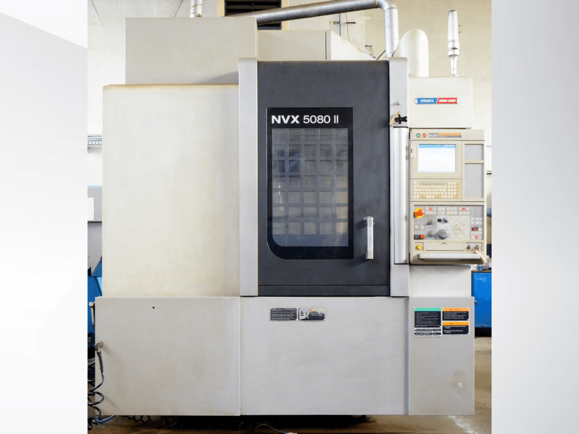 DMG Mori Seiki NVX 5080 II függőleges megmunkáló központ, elölnézet, a vezérlőpanellel és a rácsos ajtóval.