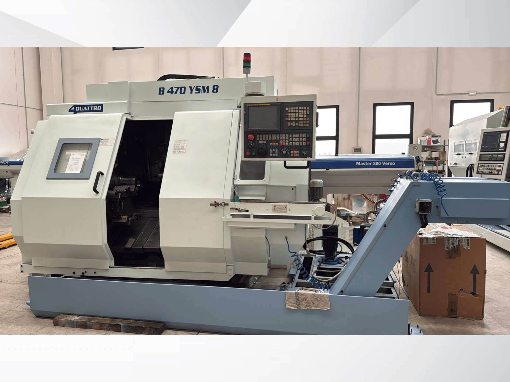 Biglia B470 YSM esztergapad-központ, elölnézetben a vezérlőpanel, a nyitott ajtó és a munkaterület a benne lévő szerszámokkal.