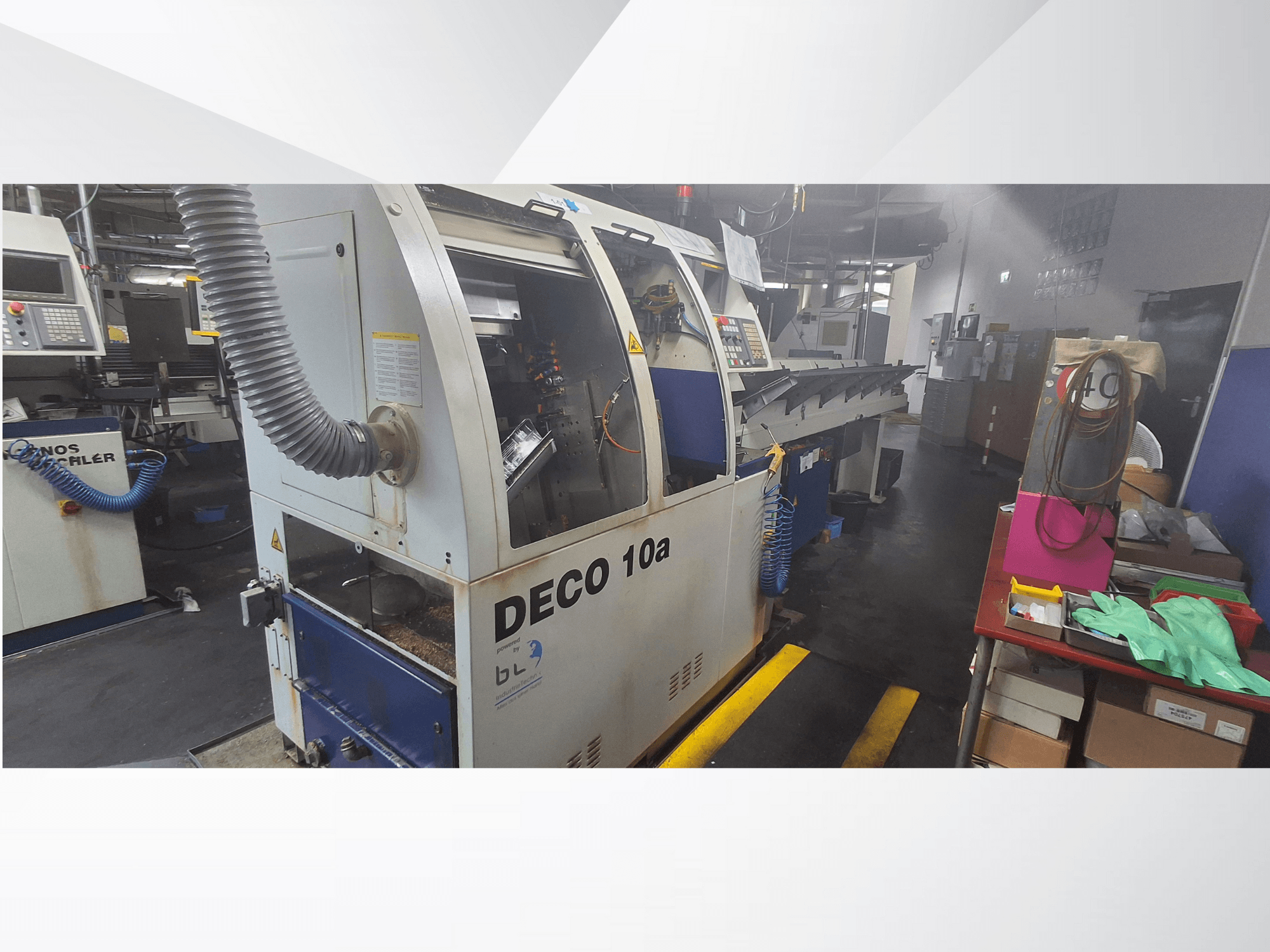 DECO 10a CNC-gép egy műhelyben, elölnézet; vezérlőpanel és porelszívó rendszer, a közelben munkapad.