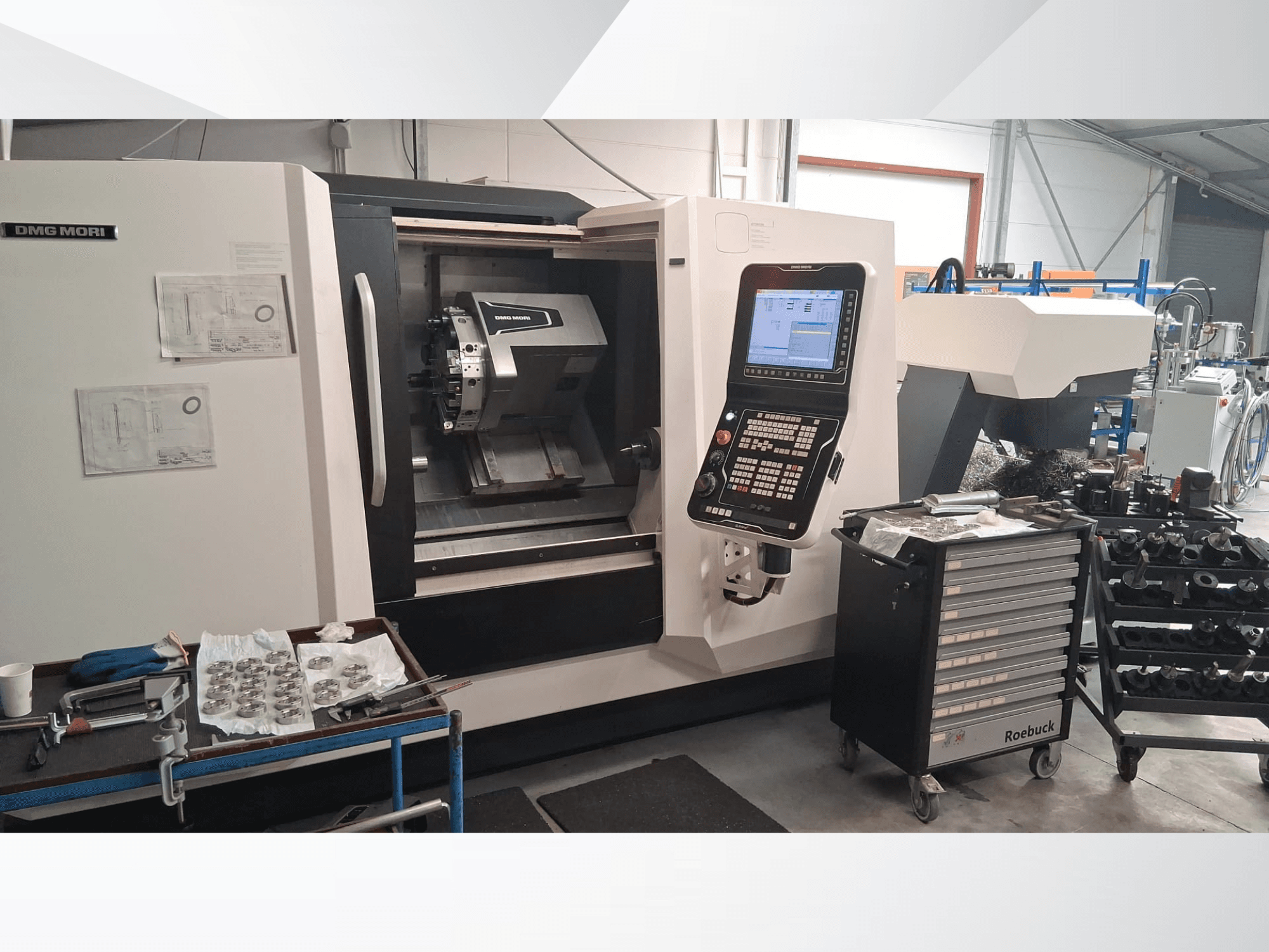 DMG MORI CLX450 vízszintes esztergagép elölnézetből, a vezérlőpanel, a munkaterület, a szerszámok és a fém alkatrészek.