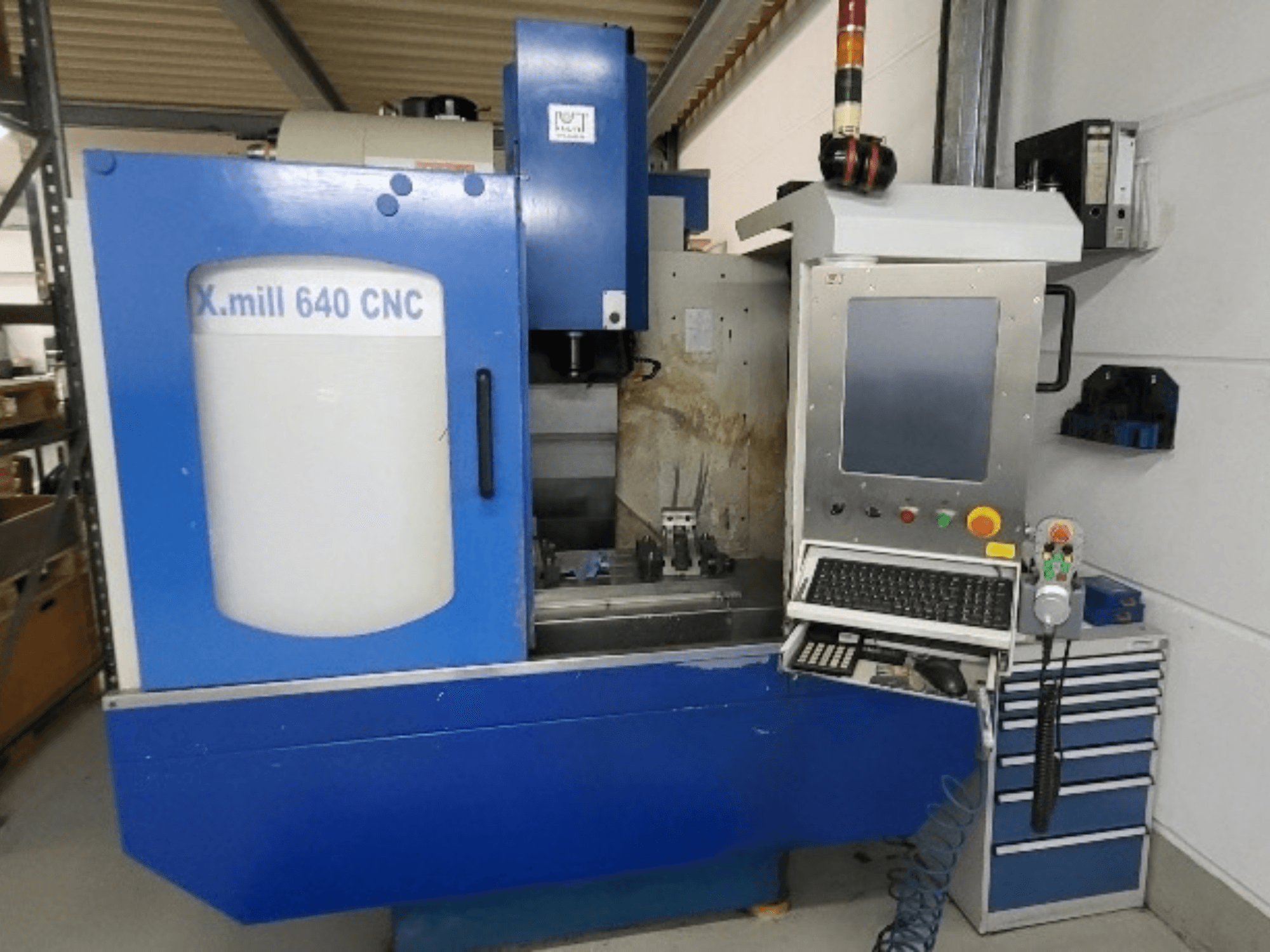 Kék KNUTH X-mill 640 CNC függőleges megmunkáló központ, elölnézet, látható a vezérlőpanel és a billentyűzet.