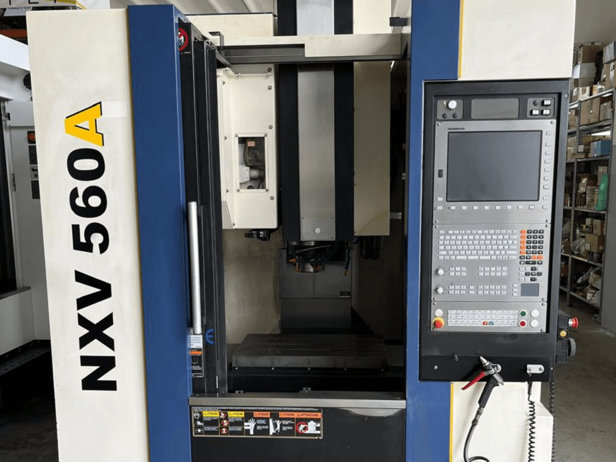NXV 560A CNC-gép elölről nézve, gombokkal és digitális kijelzővel ellátott kezelőpanellel.