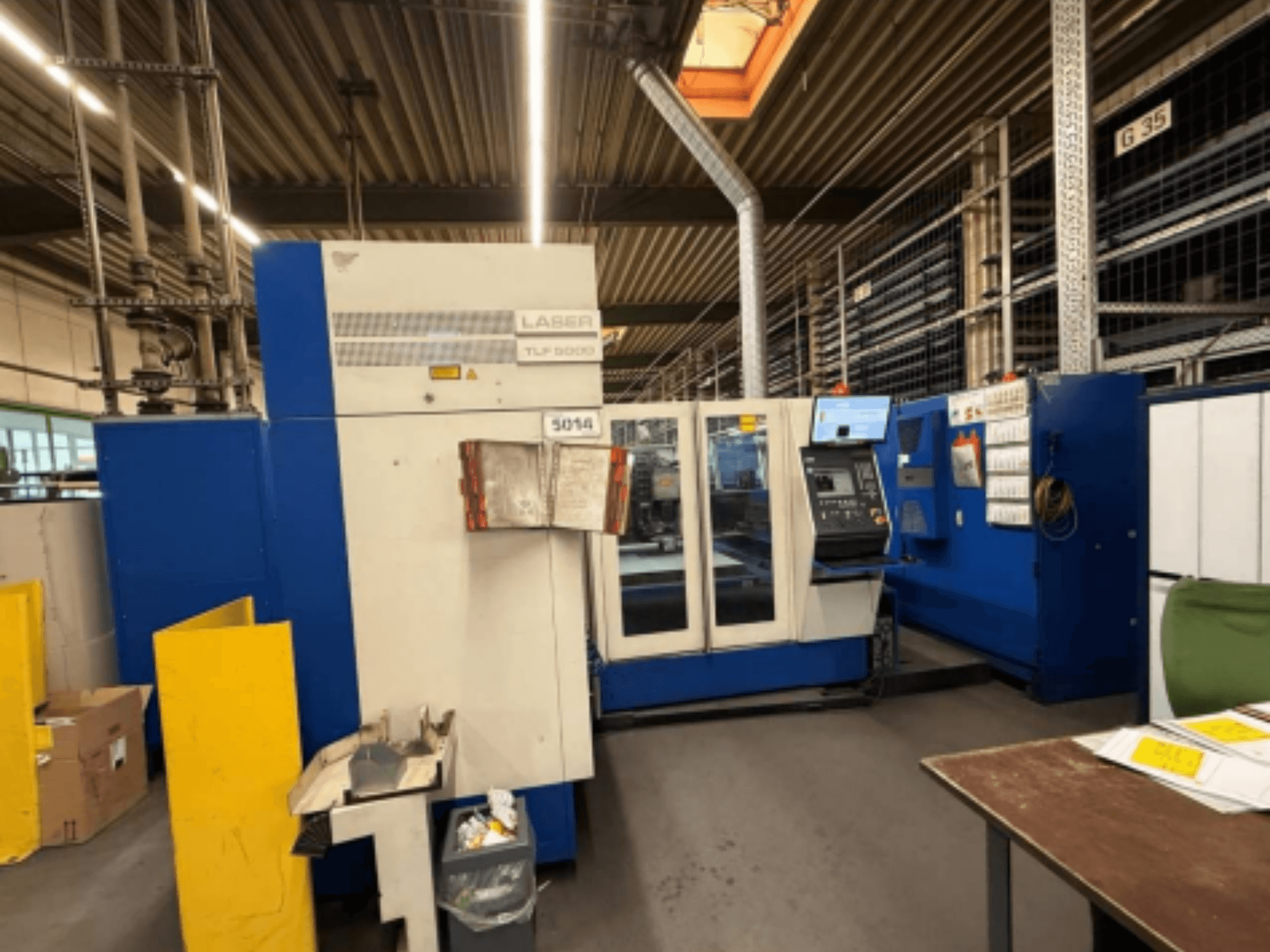 A TRUMPF Trumatic L 3050 CO2 lézervágó gép előlapja, a kezelőpanel és a működési jellemzők bemutatása egy műhelyben.