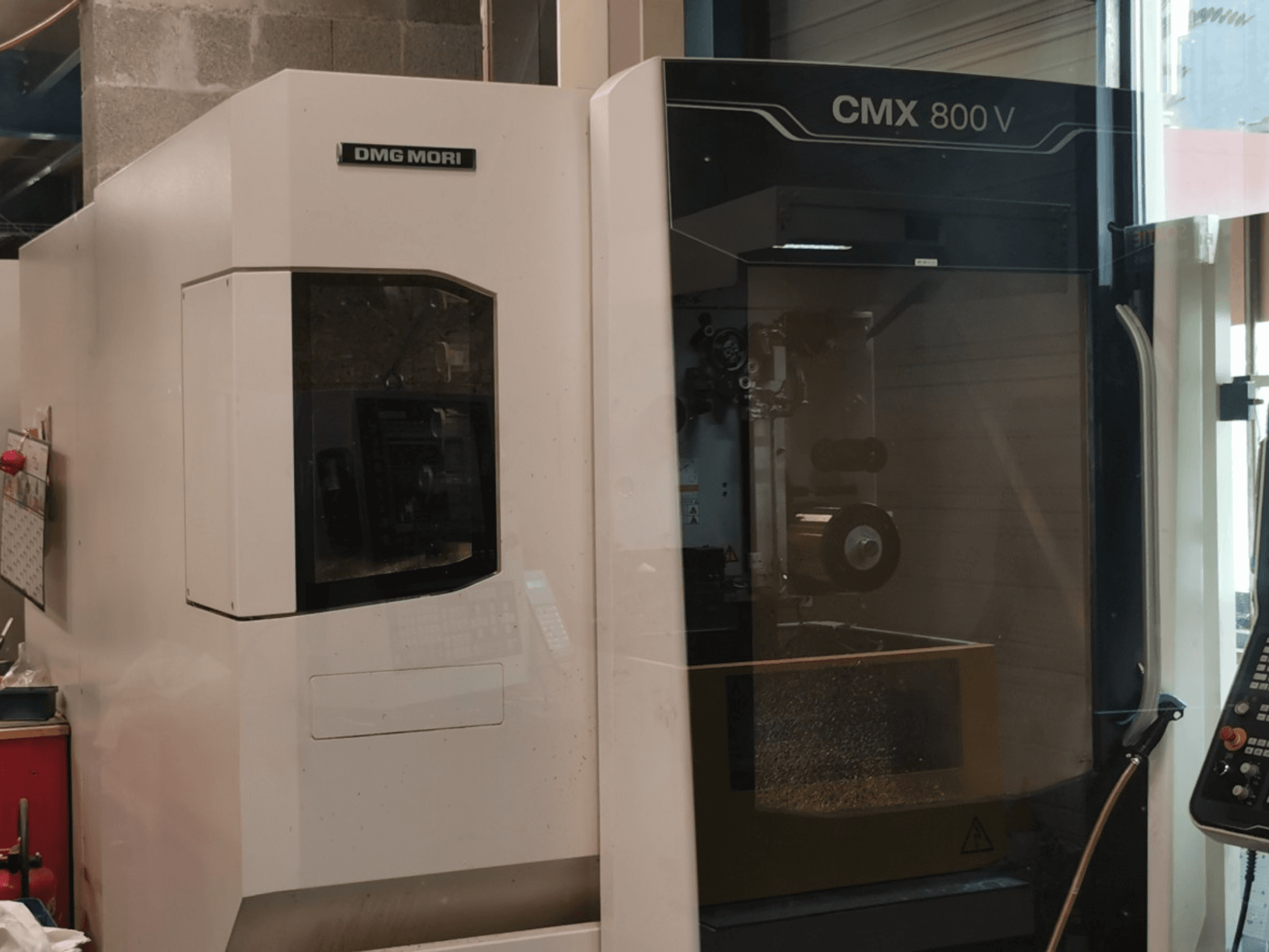 DMG Mori Seiki CMX 800 V függőleges megmunkálóközpont, elölnézet, amelyen látható a vezérlőpanel és a munkaterület a szerszámokkal együtt.