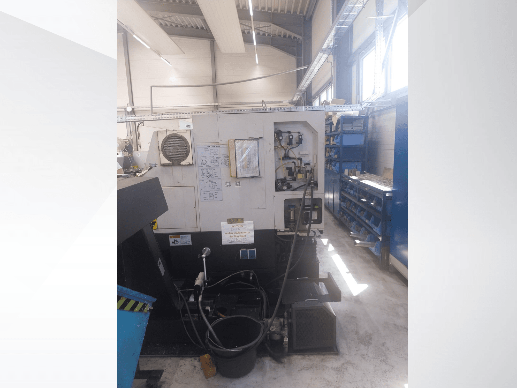 Mazak QUICK TURN NEXUS 200 MS, oldalnézet, amelyen a vezérlőpanel, a tömlők és a szerszámtartó terület látható műhelyi környezetben.