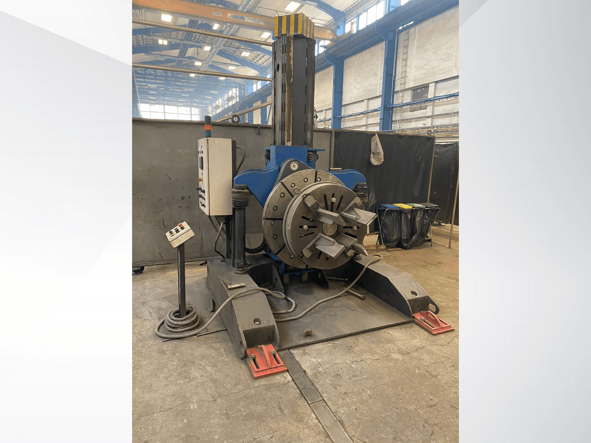 Kék ipari esztergagép kerek forgófejjel és vezérlőpanellel, oldalnézetben, műhelyben.