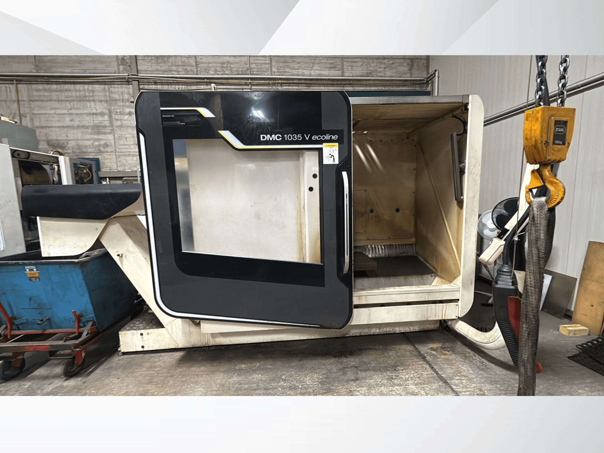 DMC 1035 V ecoline CNC-gép, elölnézet, nyitott ajtó, amely az üres belső teret és a vezérlőpanelt mutatja.