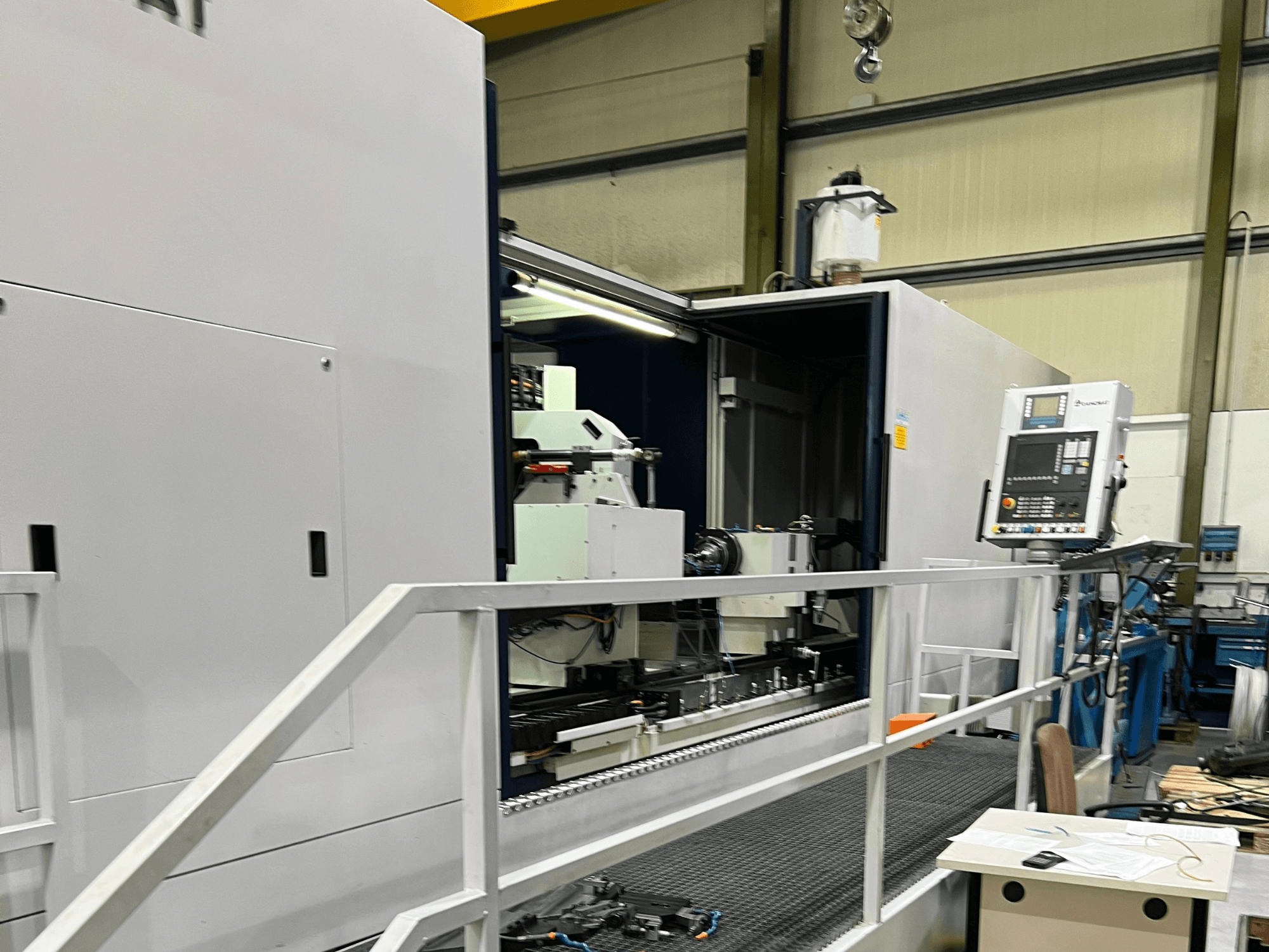 CNC megmunkálóközpont nyitott oldalnézetben, a kezelőszervek, a szerszámtartó és a fő alkatrész bemutatásával. A márka részletei nem láthatók.