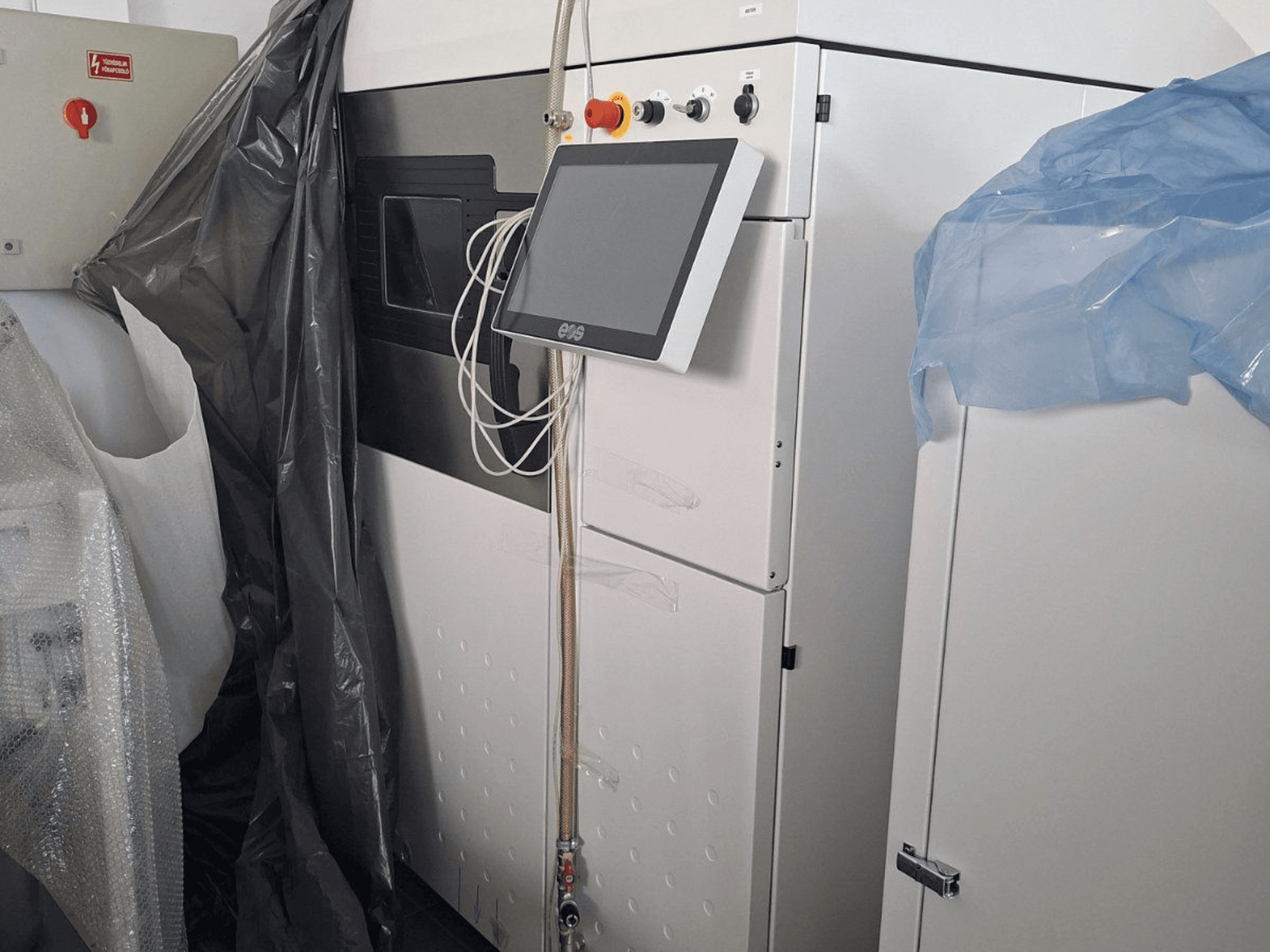 EOS M 290 fém 3D nyomtató előlapja, érintőképernyővel, vezérlőpanellel és védőburkolattal.