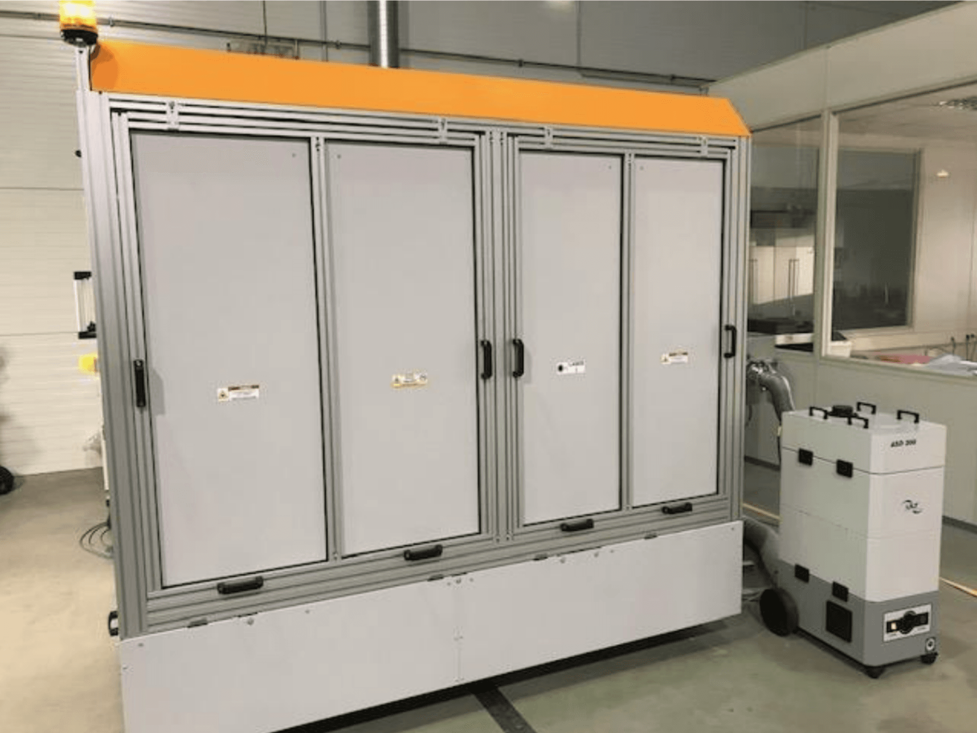 4JET Pearl M szálas lézervágógép, előlnézet, látható a biztonsági lámpa, a vezérlőpanel és a csatlakoztatott elszívóegység.