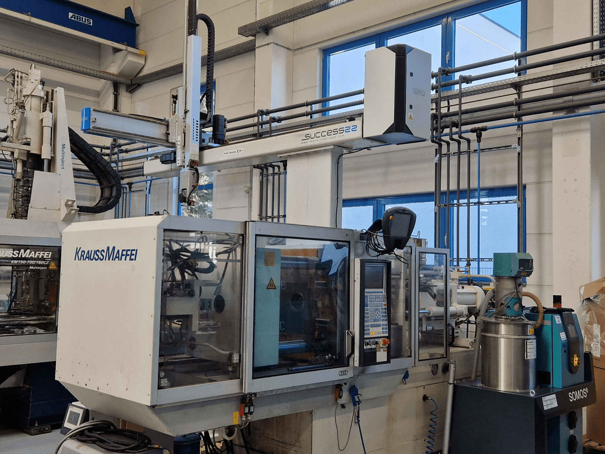 KraussMaffei Success 22 fröccsöntőgép vezérlőpanellel, szemből, gyári környezetben.