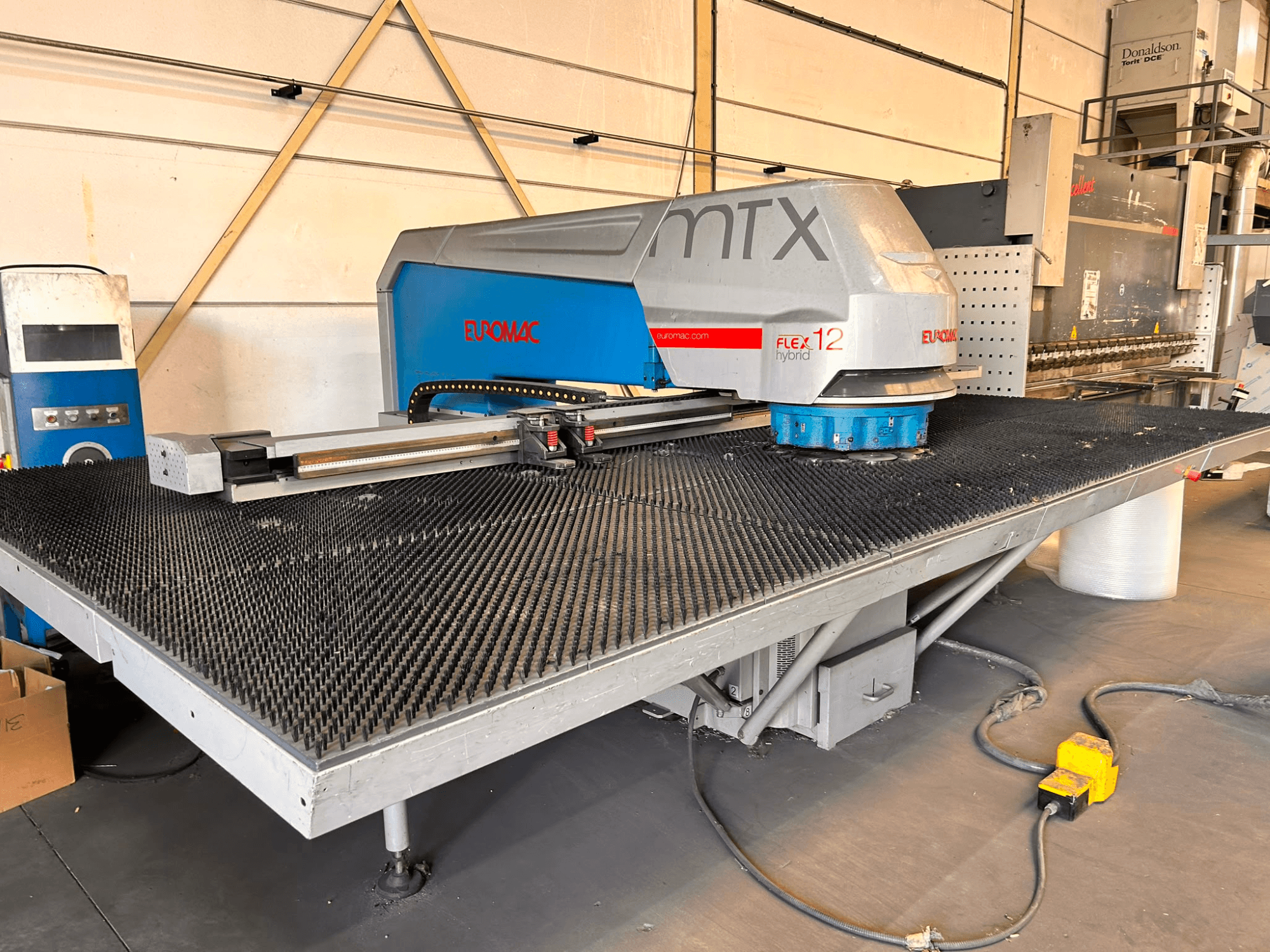 Euromac MTX FLEX 12 CNC lyukasztógép, elölnézet, nagy lyukacsos asztallal és vezérlőpanellel.