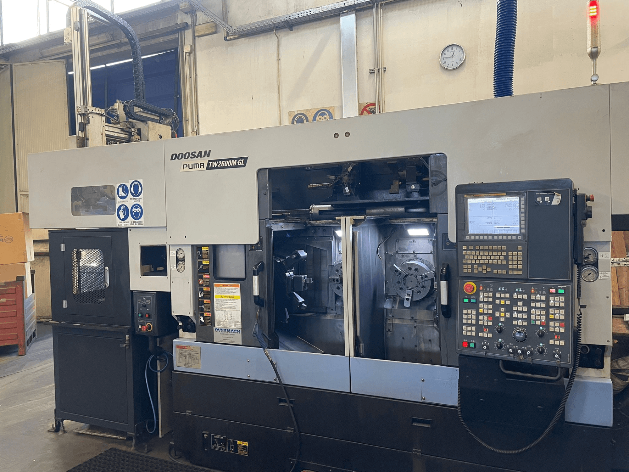 Doosan Puma TW2600M GL CNC eszterga, előlnézet, a digitális vezérlőpanel és a gép belseje a szerszámtartókkal.