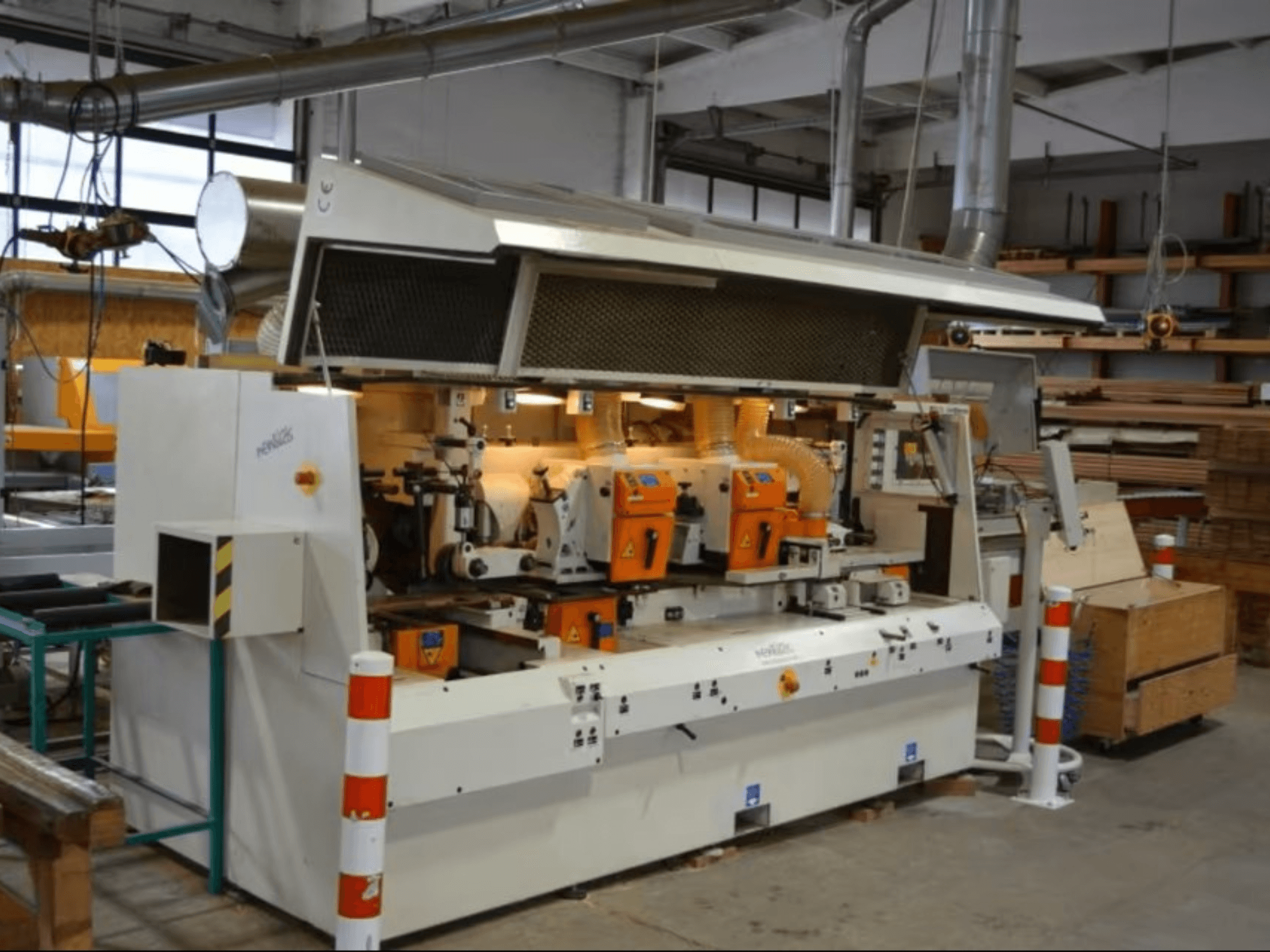 PENIGAS fafeldolgozó gép, elölnézetben, két narancssárga vágófejjel és porelszívó rendszerrel műhelyben.