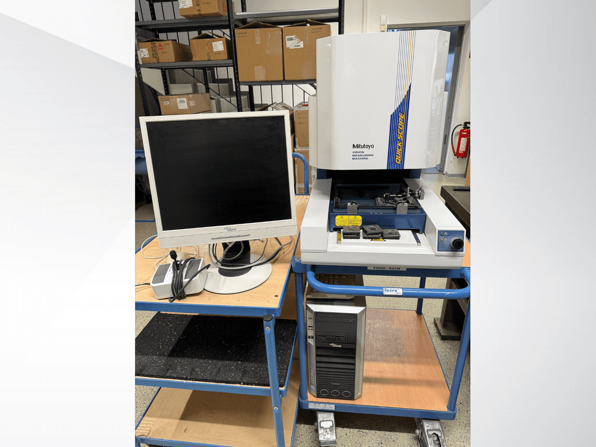 Mitutoyo Quick Scope látásmérő gép monitorral, PC-vel és tartozékokkal, elölnézetben, kék kocsin.