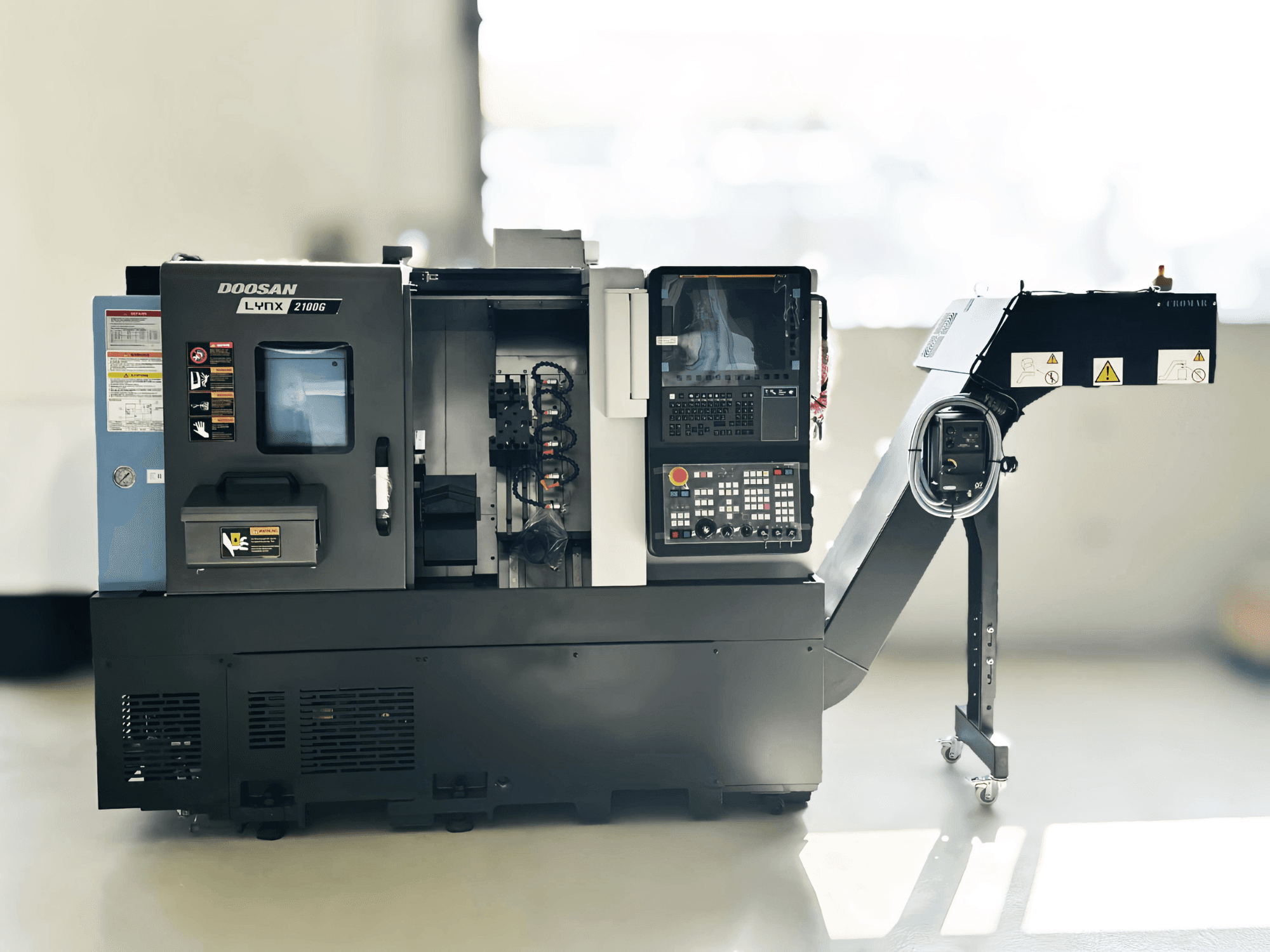 DOOSAN LYNX 2100GA svájci típusú esztergagép oldalnézetben, a vezérlőpanel és a szerszámtartó látható.