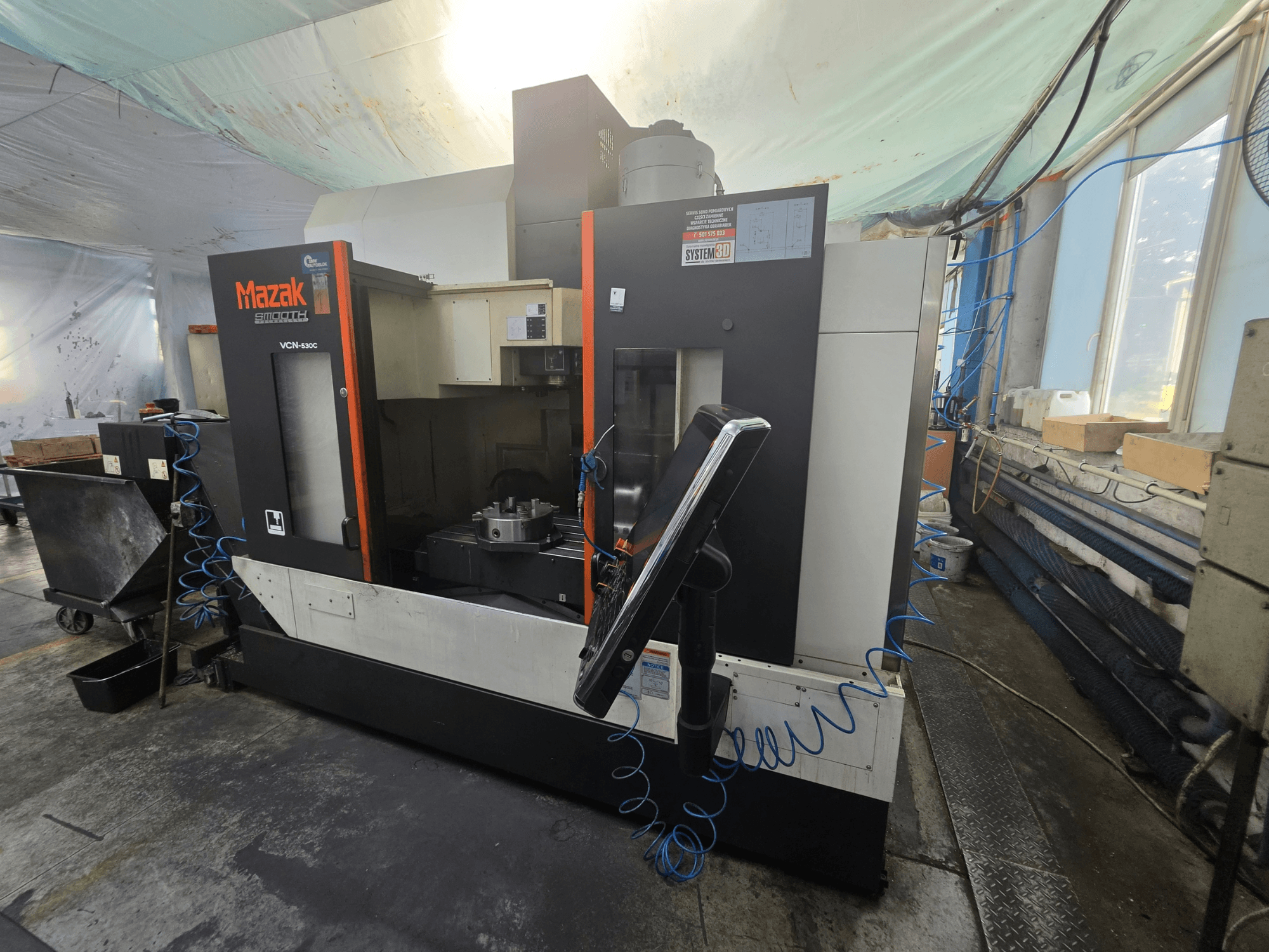 A Mazak VCN-530C függőleges megmunkáló központ elölnézete, amelyen látható a vezérlőpanel, a munkaterület és a szerszámtartó.