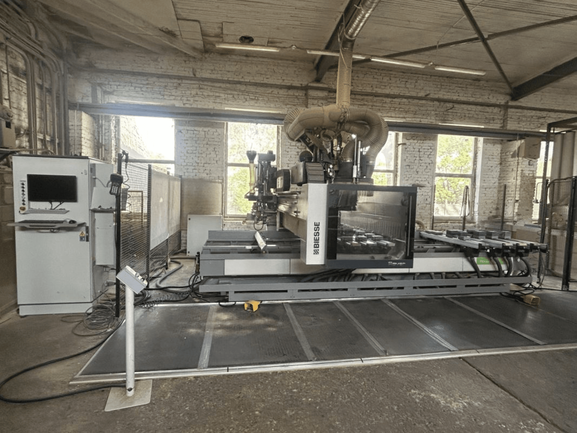 BIESSE Rover A Edge 1643 CNC megmunkáló központ, elölnézet, a vezérlőpanellel, a munkapaddal és az ipari környezettel.
