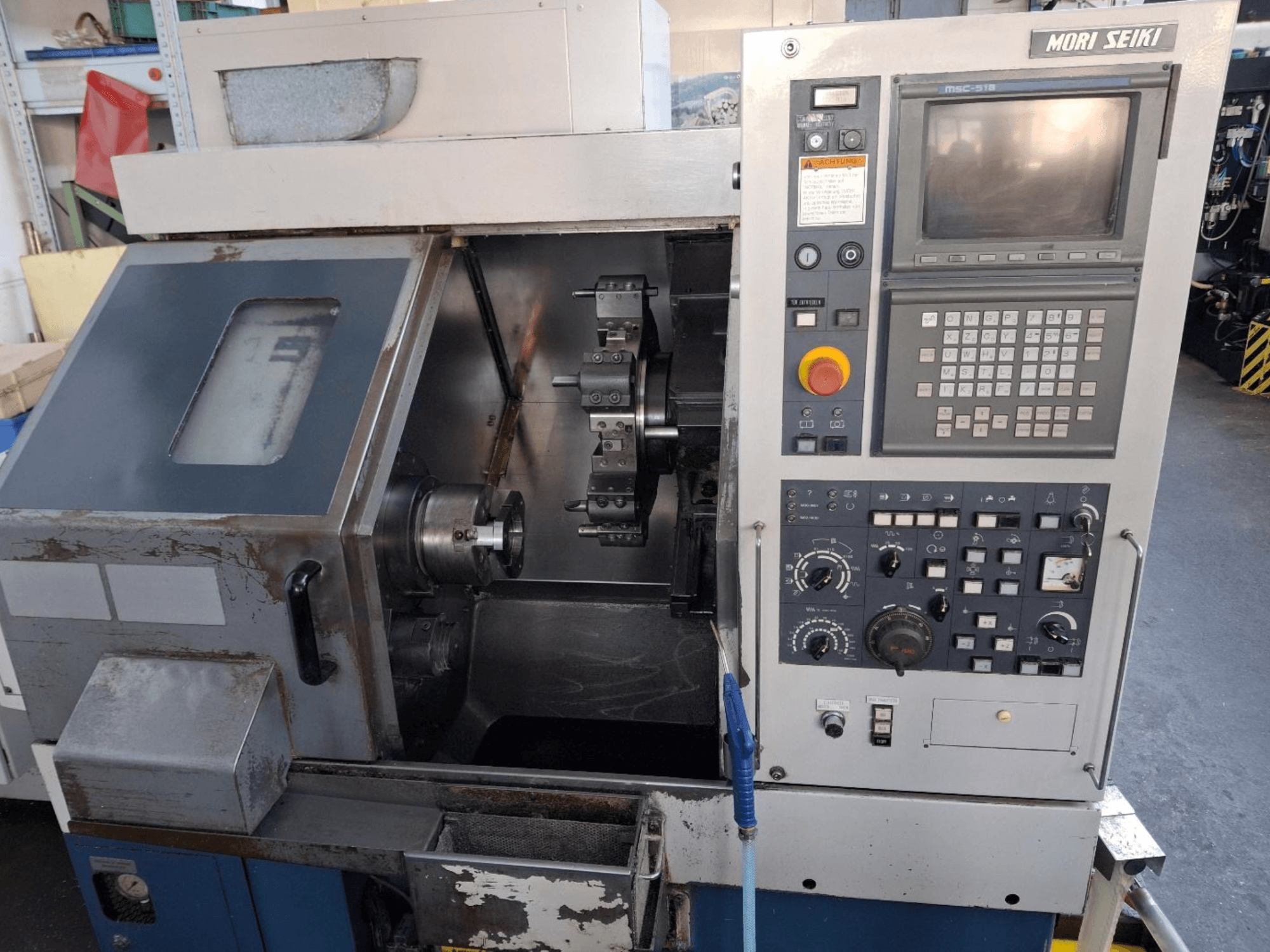 MORI SEIKI CL 15 vízszintes esztergagép, elölnézetben a vezérlőpanel és a megmunkálási terület.