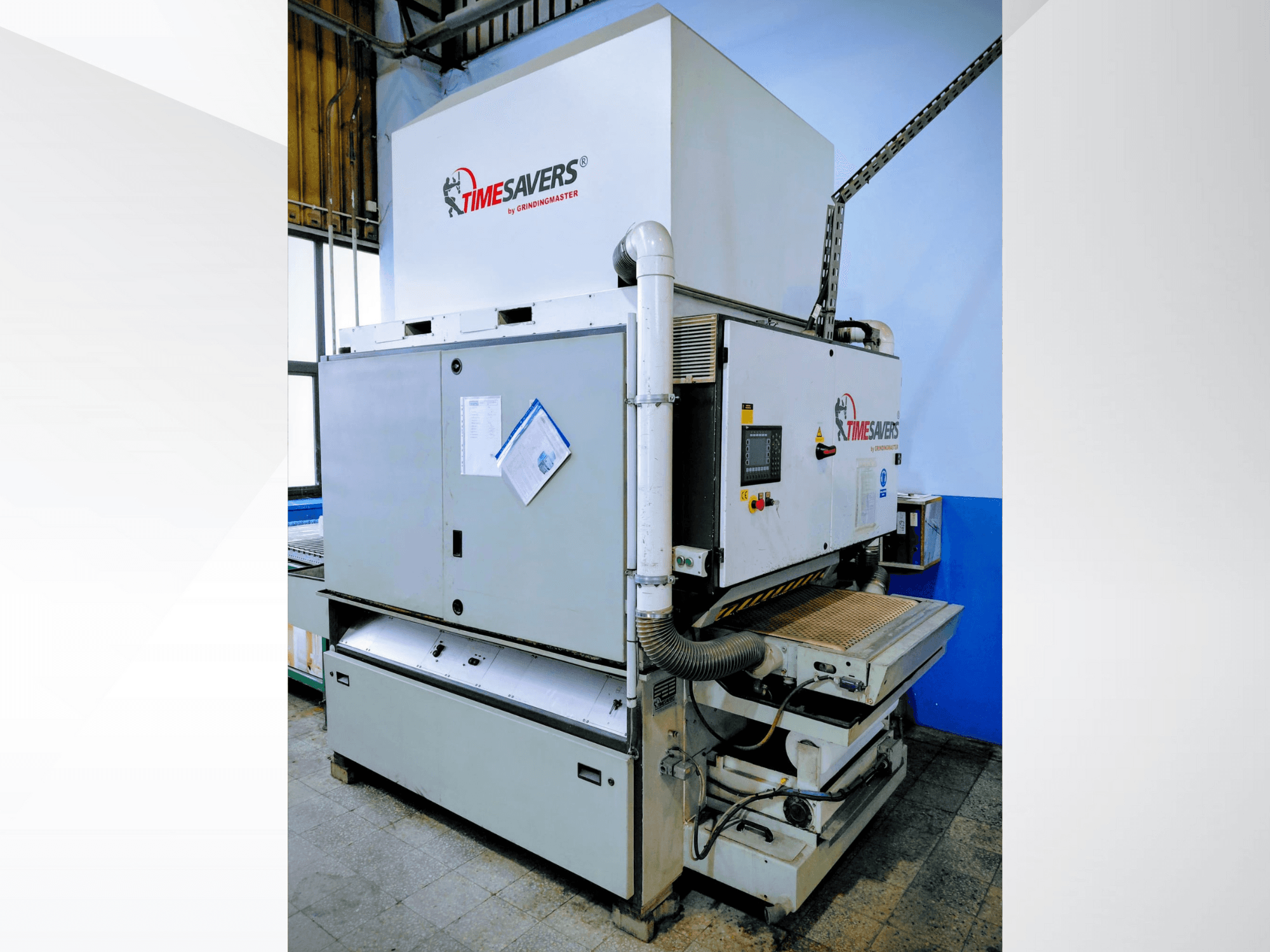 Timesavers ipari csiszológép, elölnézet. Működtető kezelőszervek, porelszívás és állítható csiszolóágy a pontosság érdekében.