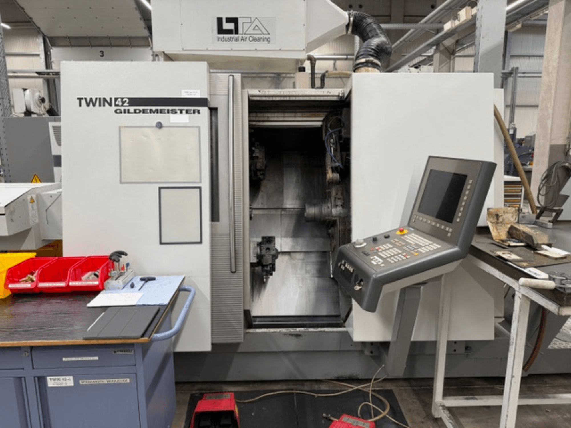 Gildemeister TWIN 42 vízszintes eszterga, elölnézet a vezérlőpanellel és a nyitott munkaterülettel.