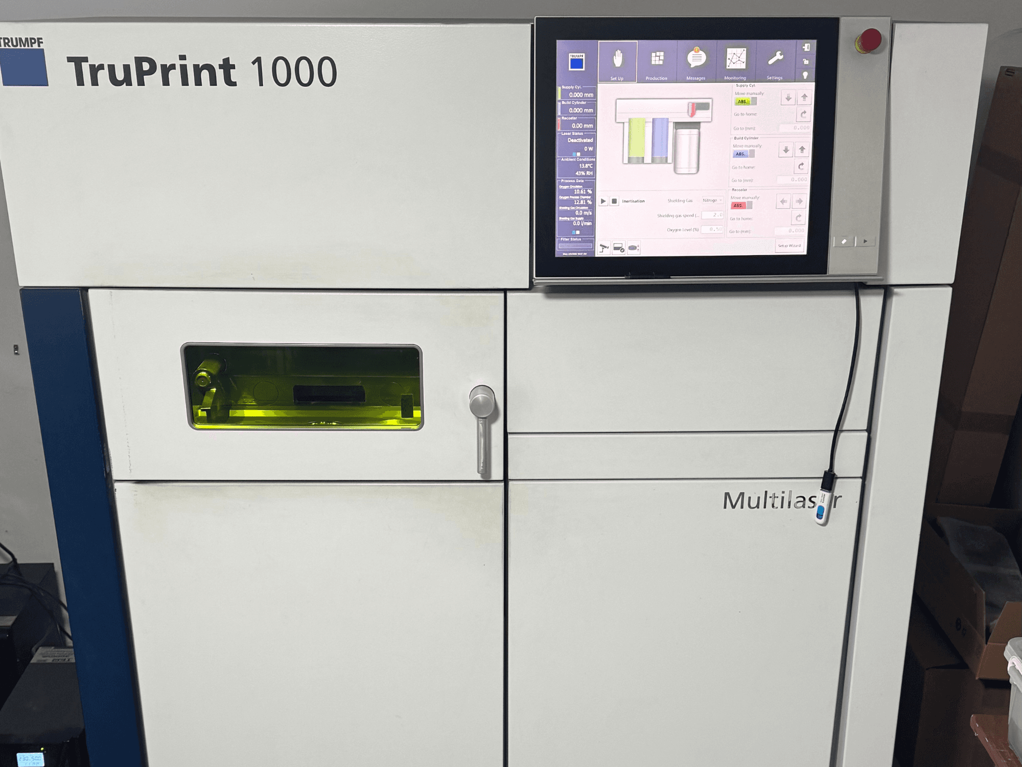 A Trumpf TruPrint 1000, előlnézet, digitális vezérlőpanellel és átlátszó ablakkal a felügyelethez.