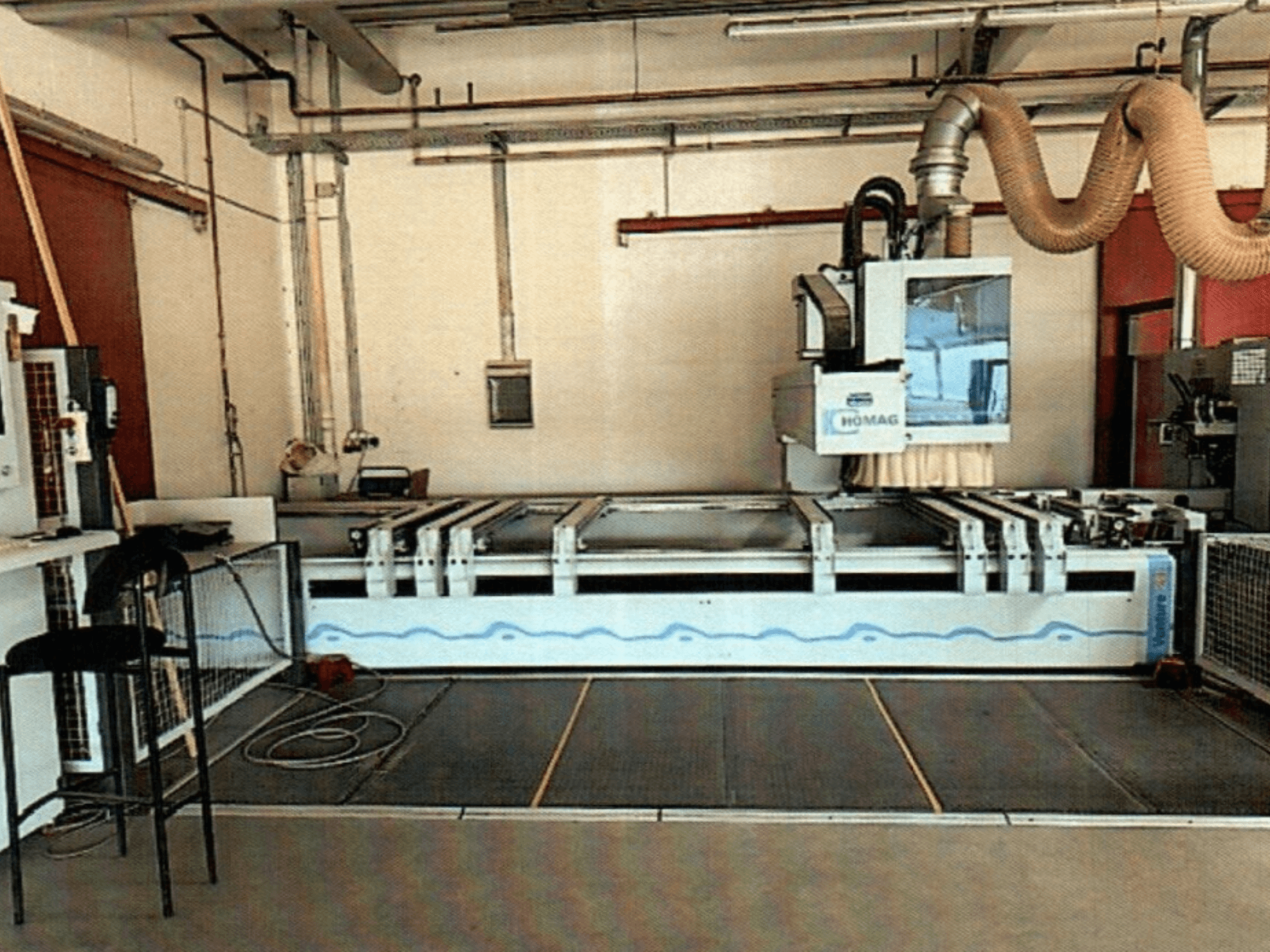 HOMAG BAZ 211/40K CNC faipari megmunkálóközpont egy műhelyben, a gép kezelőpaneljét és vágási területét bemutatva.