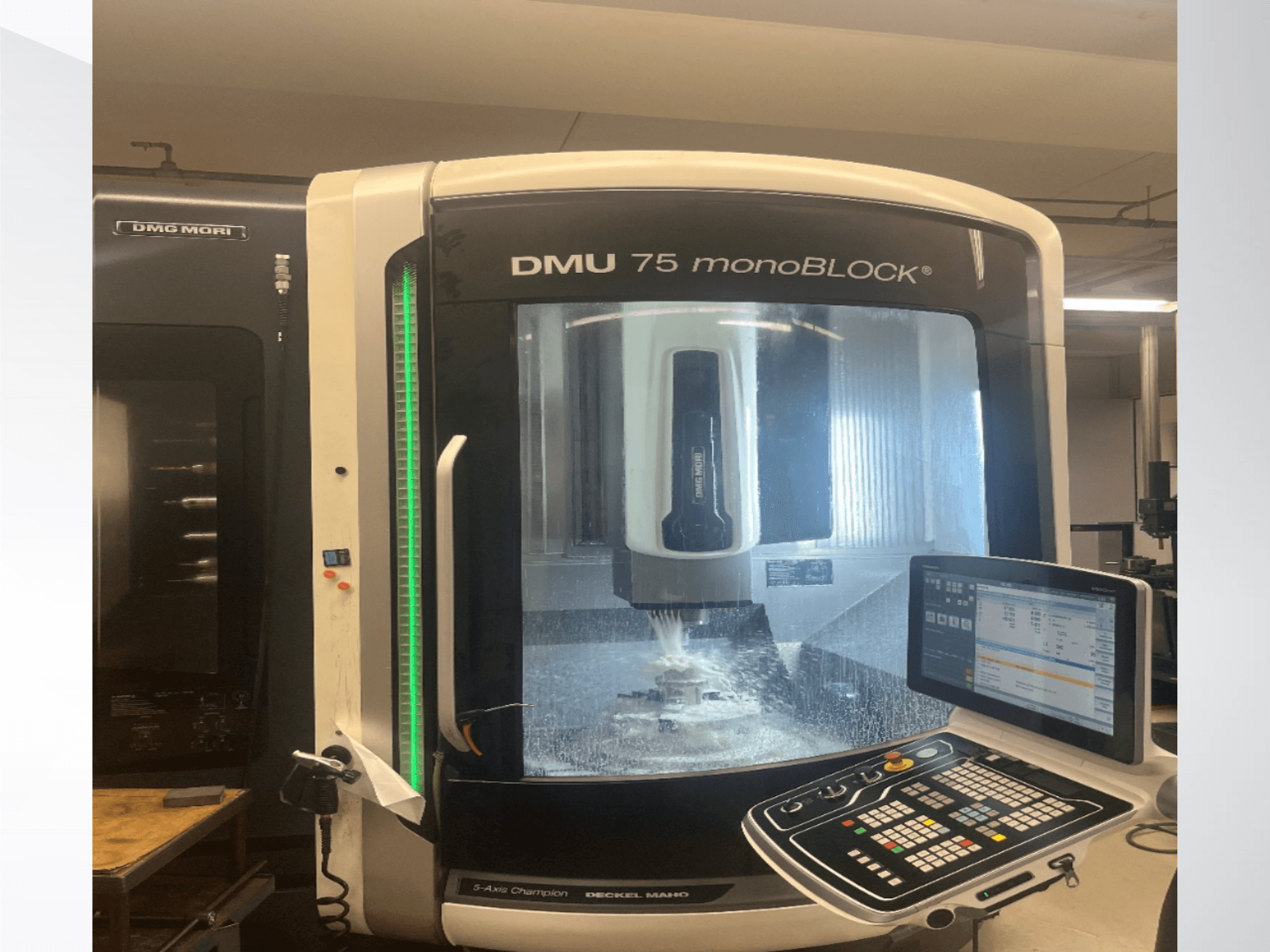 A DMG MORI DMU 75 monoBLOCK univerzális megmunkáló központ elölnézetben, a vezérlőpult és a marási terület látható.