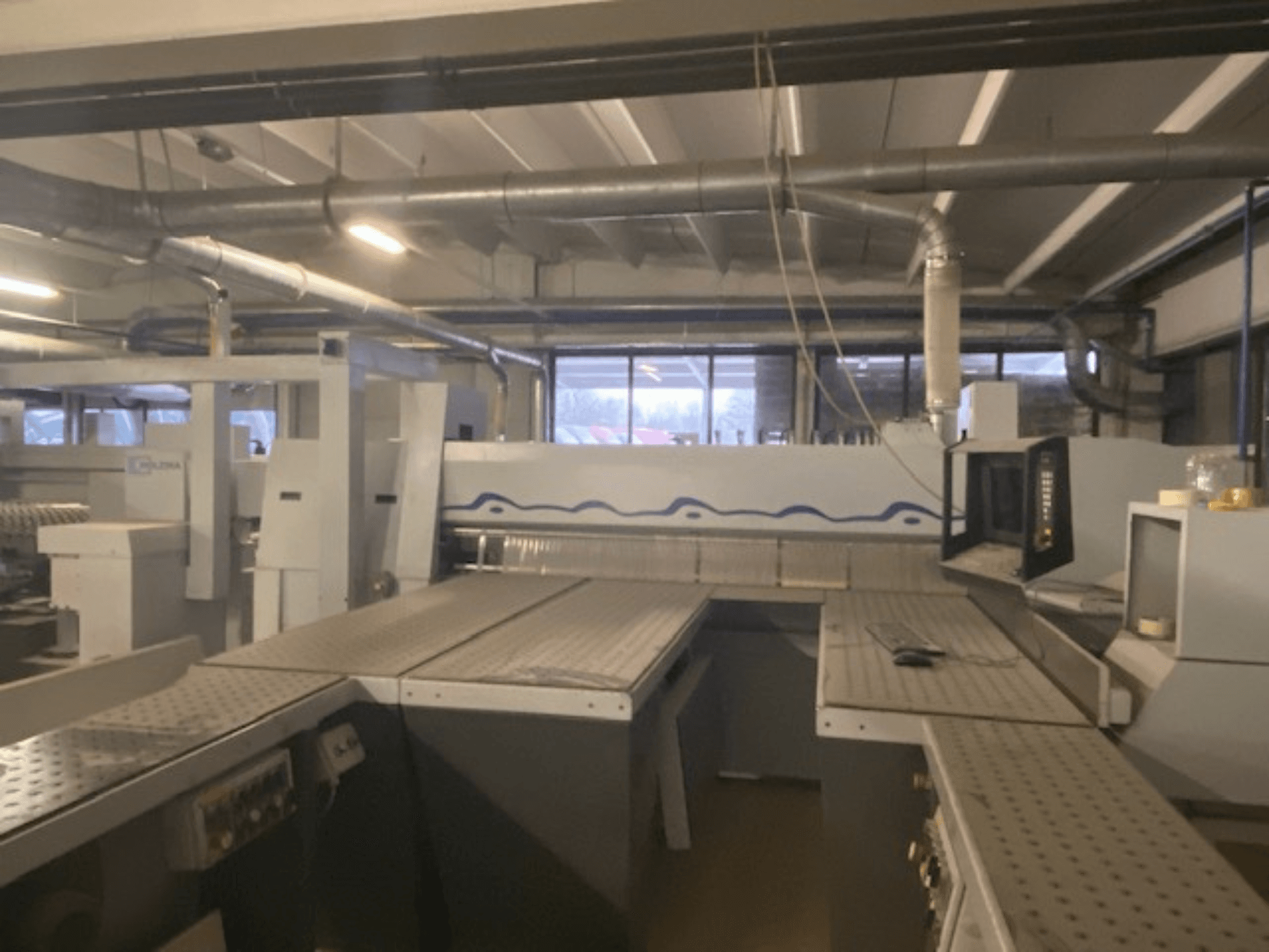 Ipari munkaterület, ahol a gépeket vezérlőpanellel együtt állítják fel, magasított szögből nézve.