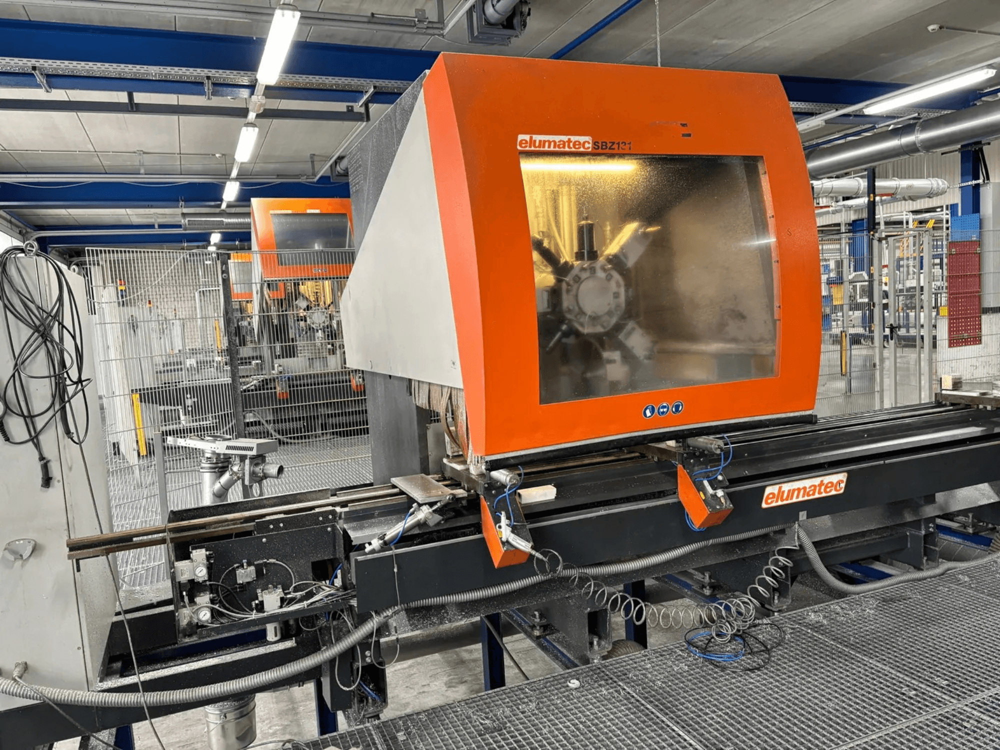 Elumatec SBZ 131 függőleges megmunkálóközpont, előlnézet, a vezérlőpanel, a gép részletei és a környező munkakörnyezet bemutatása.