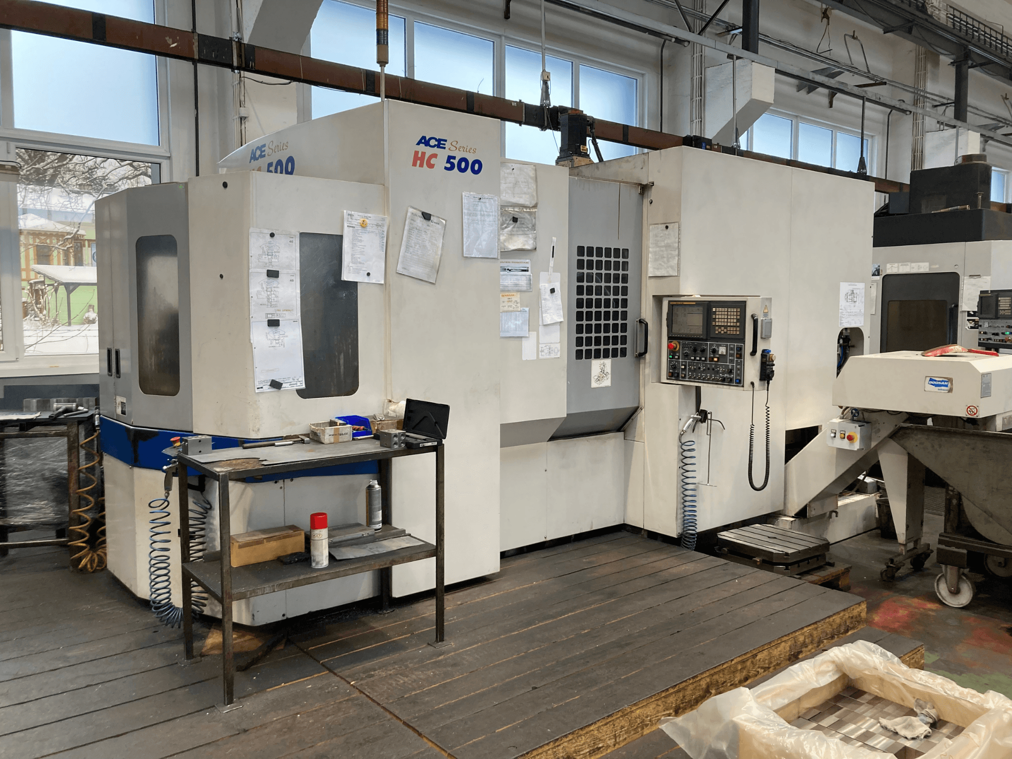DOOSAN ACE HC-500 vízszintes megmunkálóközpont, előlnézet; vezérlőpanel, több szerszámtároló és ipari beállítás.
