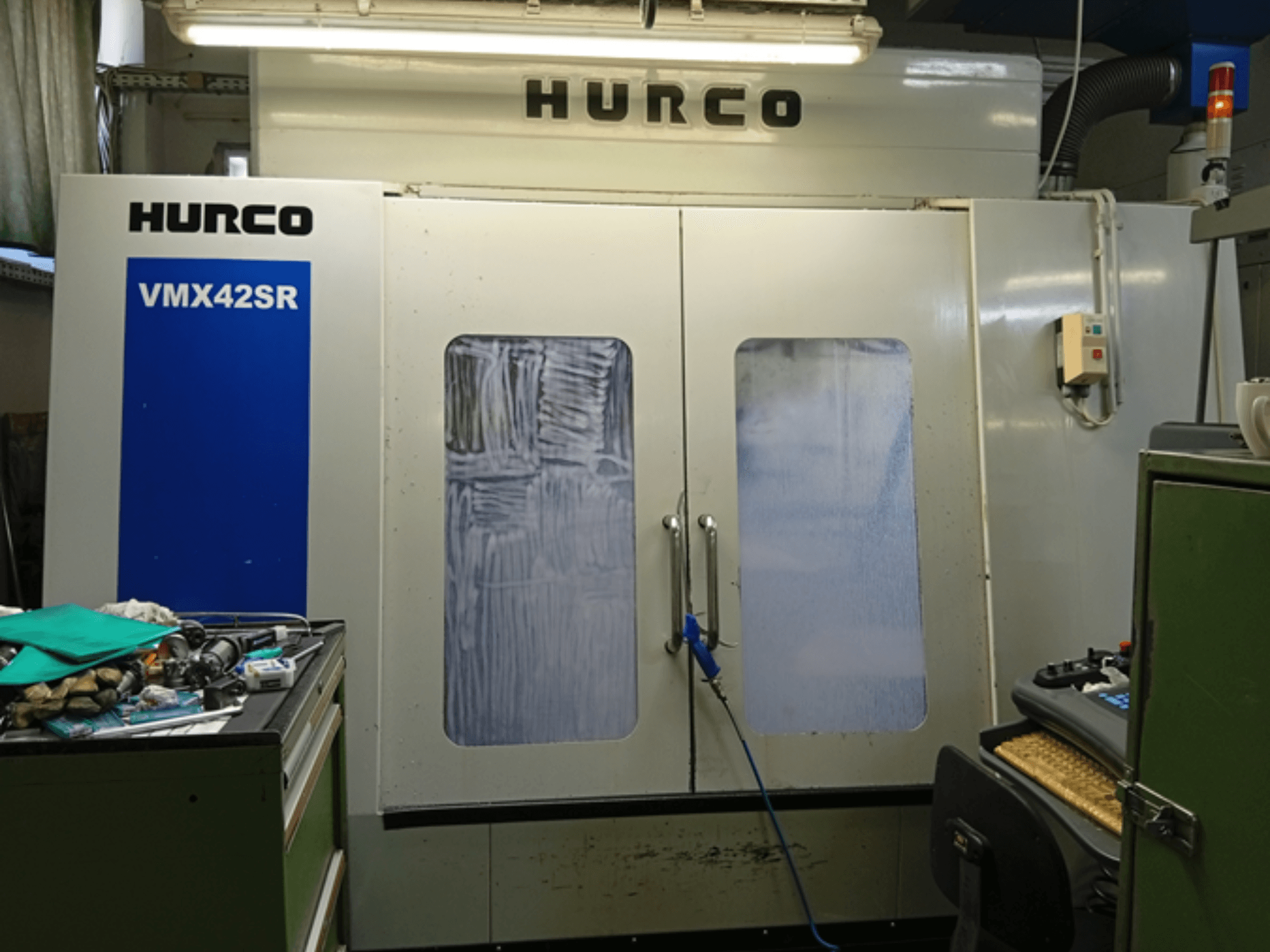 Hurco VMX 42SR függőleges megmunkálóközpont elölnézetben, kék panellel, vezérlőfelülettel és tiszta munkaterülettel.