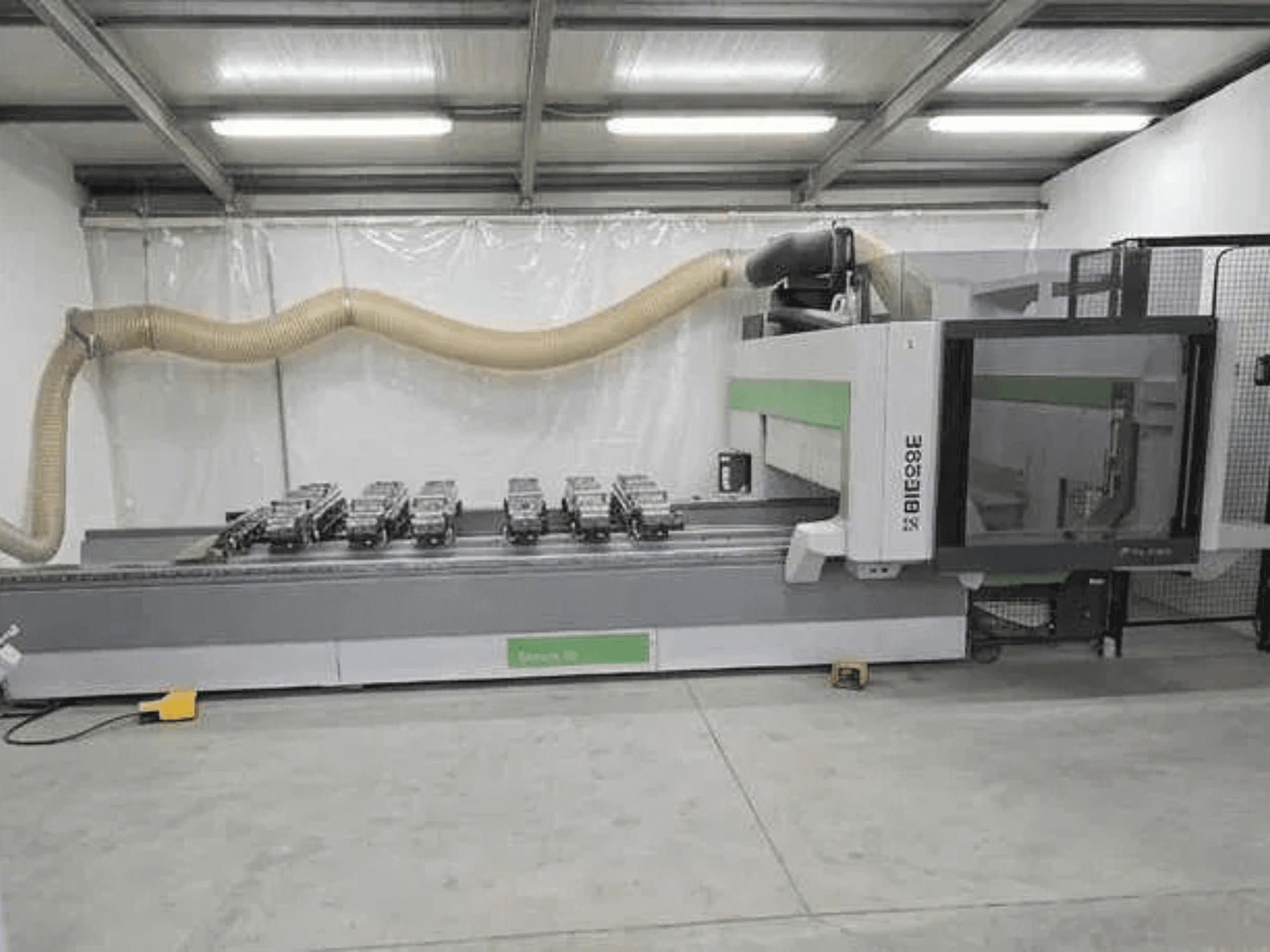 A BIESSE Rover K1232 CNC megmunkálóközpont oldalnézete, amelyen láthatók a vákuumtapadókorongok és a porelszívó rendszer.