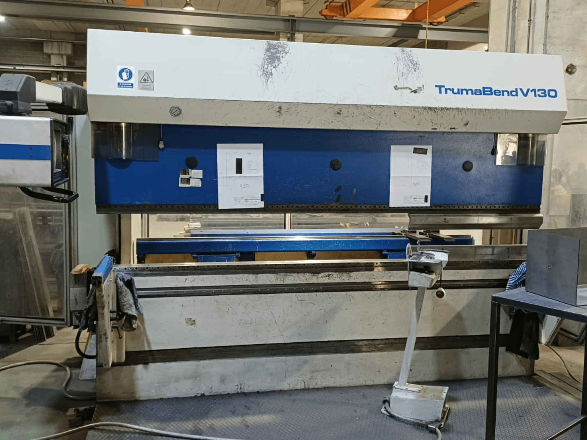 A TRUMPF Trumatic Trumabend V130 hajlítógép elölnézetben, a vezérlőpanellel, a munkaterülettel és az állítható szerszámokkal.