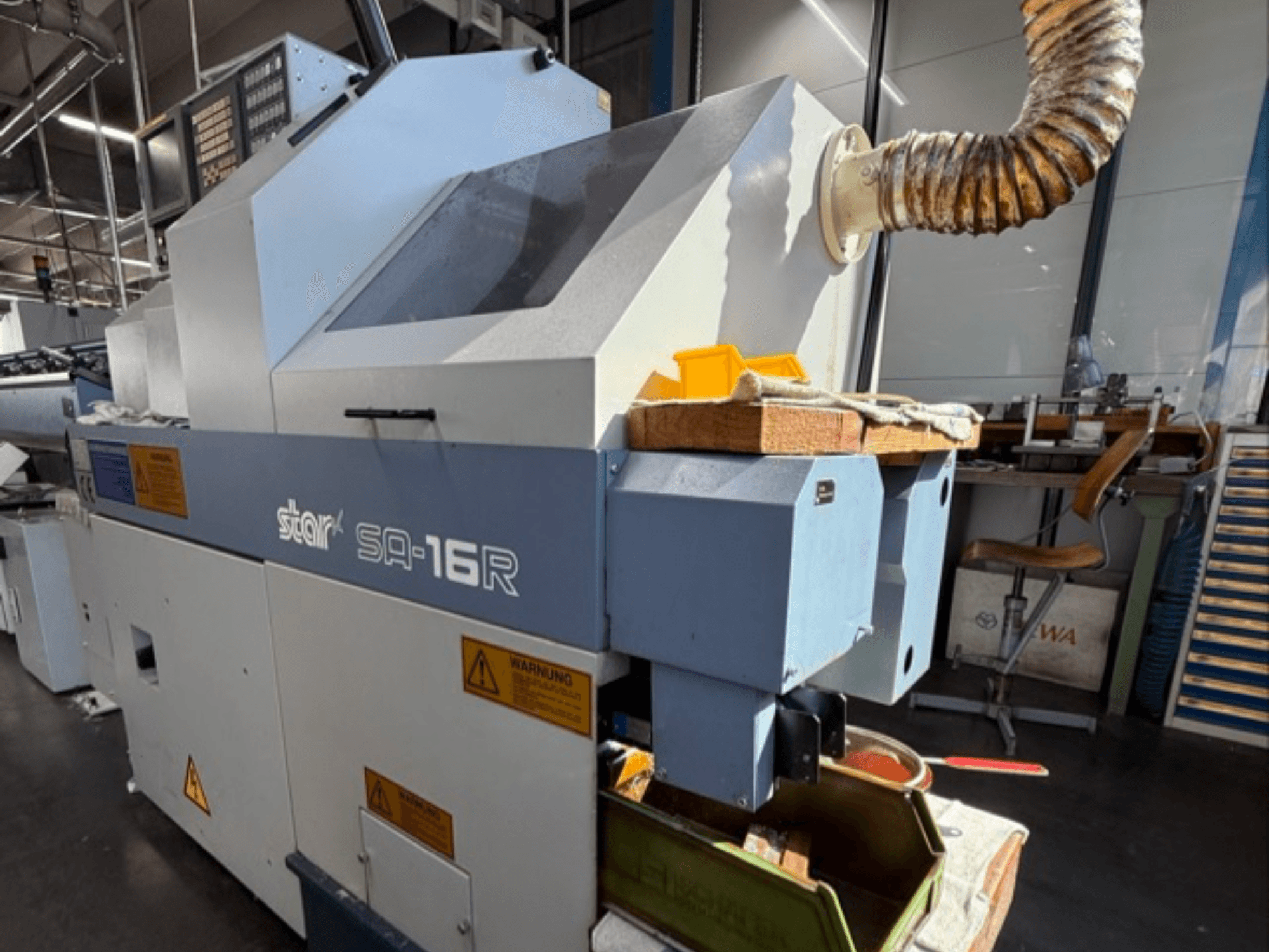 Stark SA-16R gép szemből nézve, kúpos kipufogó és sárga szerszámokkal és figyelmeztető címkékkel ellátott munkaterület.