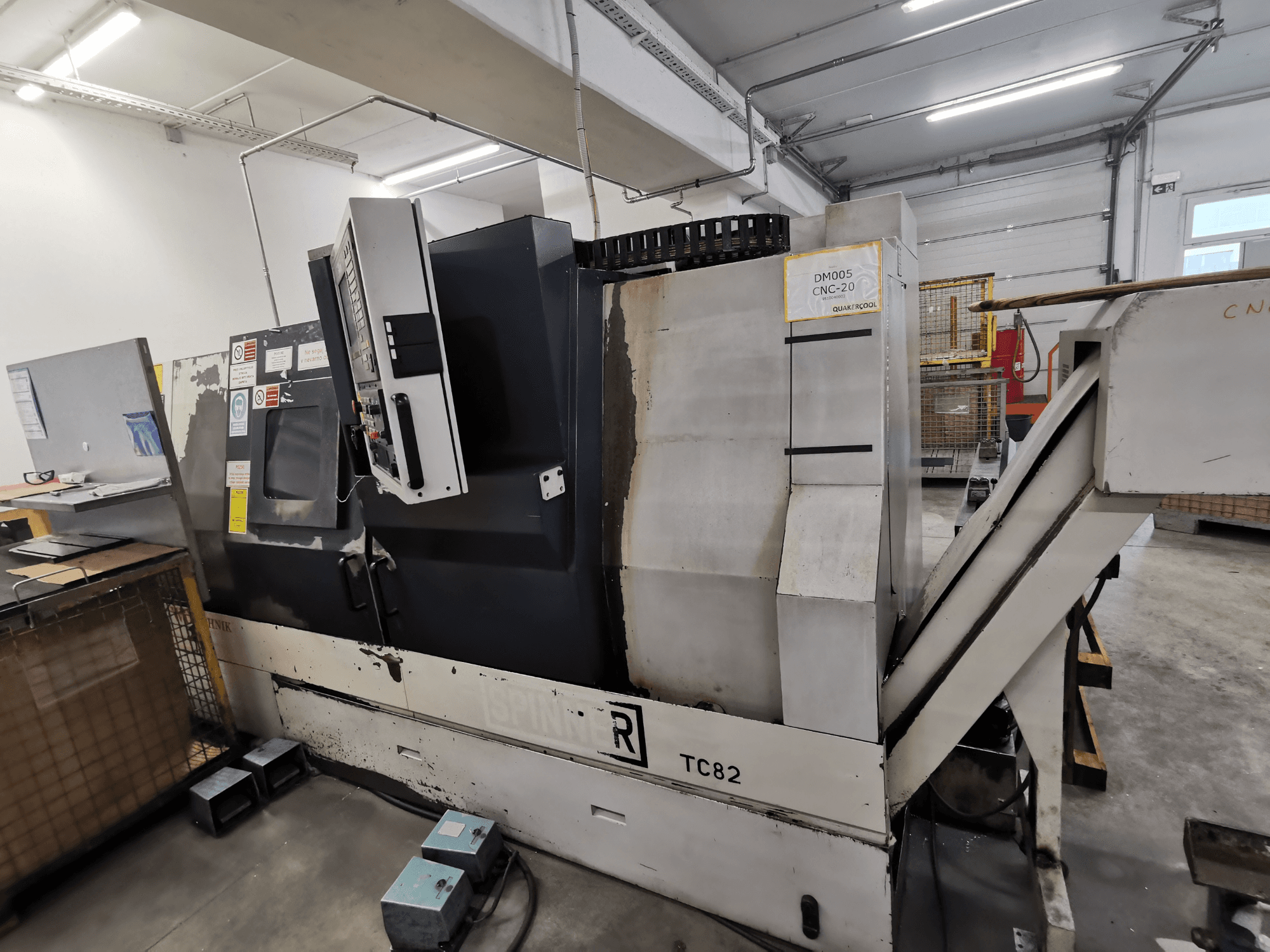 CNC-gép, márka Spinner, TC82 modell, oldalnézet a vezérlőpanel és a törmelékelszívó csúszda műhelyben.