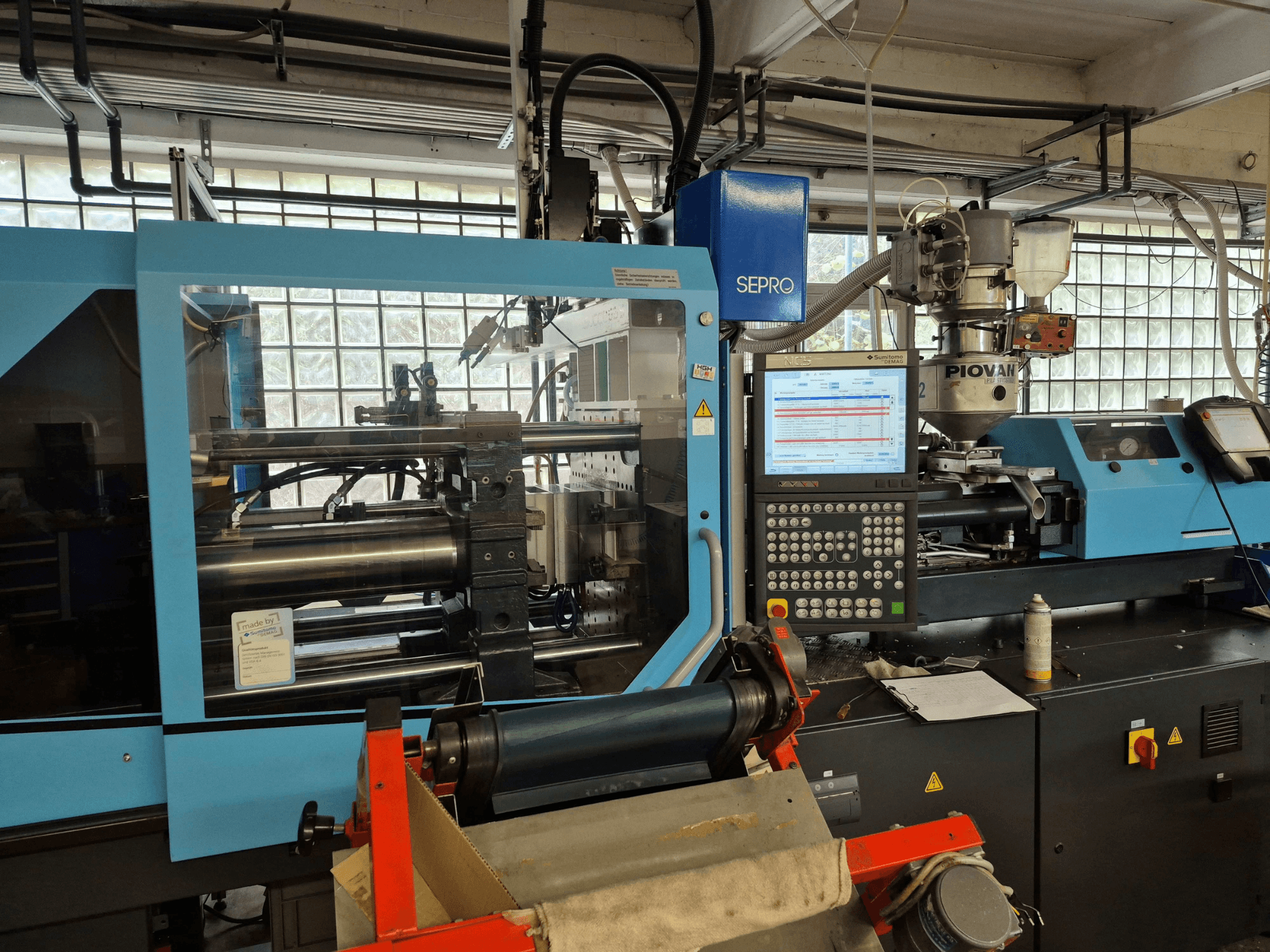 SUMITOMO SHI DEMAG Systec 120/470-430 hidraulikus fröccsöntőgép, elölnézet, amelyen látható a vezérlőpanel és az adagolórendszer.