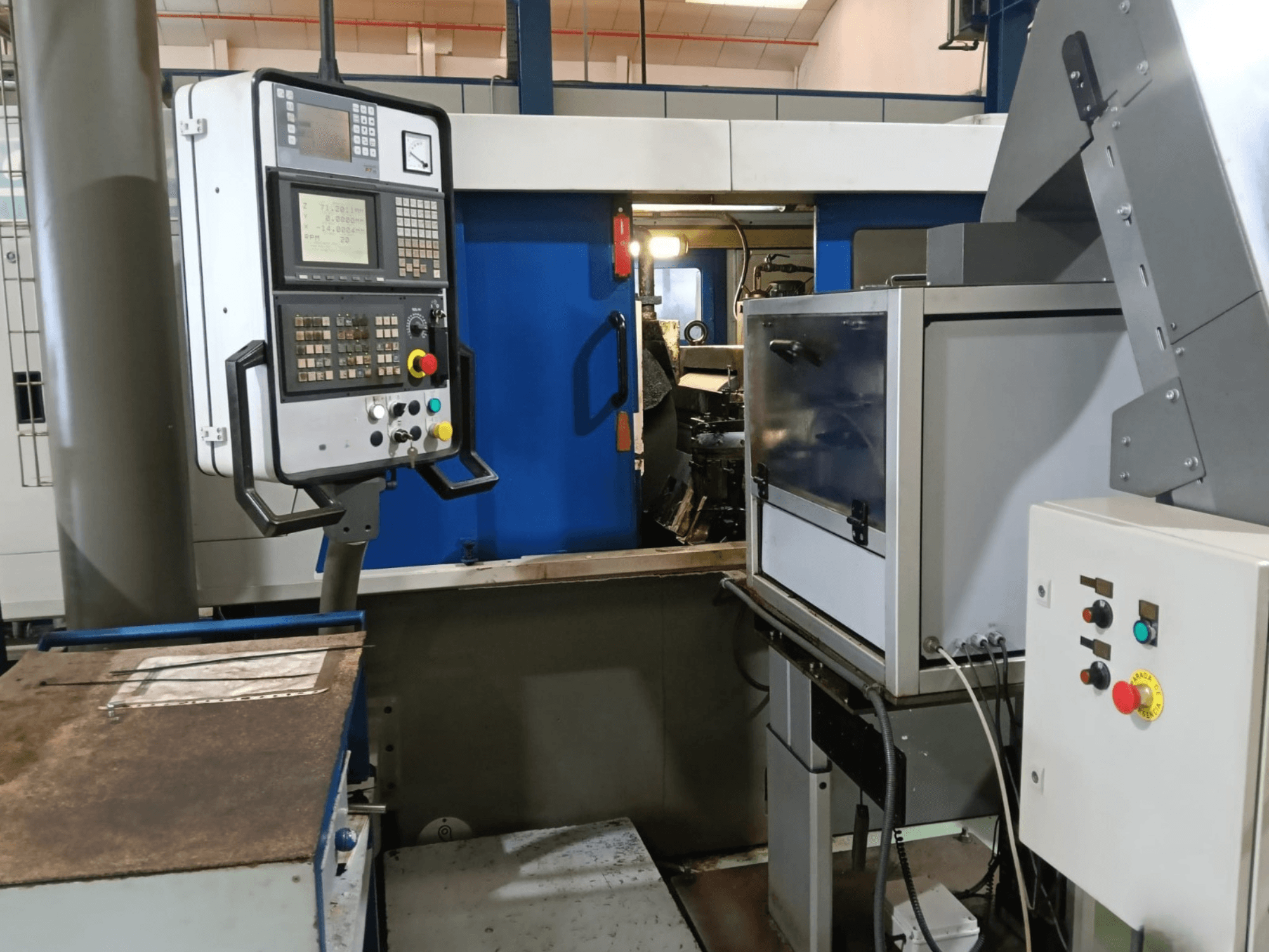 A DANOBAT 327 MDA központ nélküli köszörűgép vezérlőpanelje és gépezete oldalról nézve, a gombok és a kijelző bemutatásával.