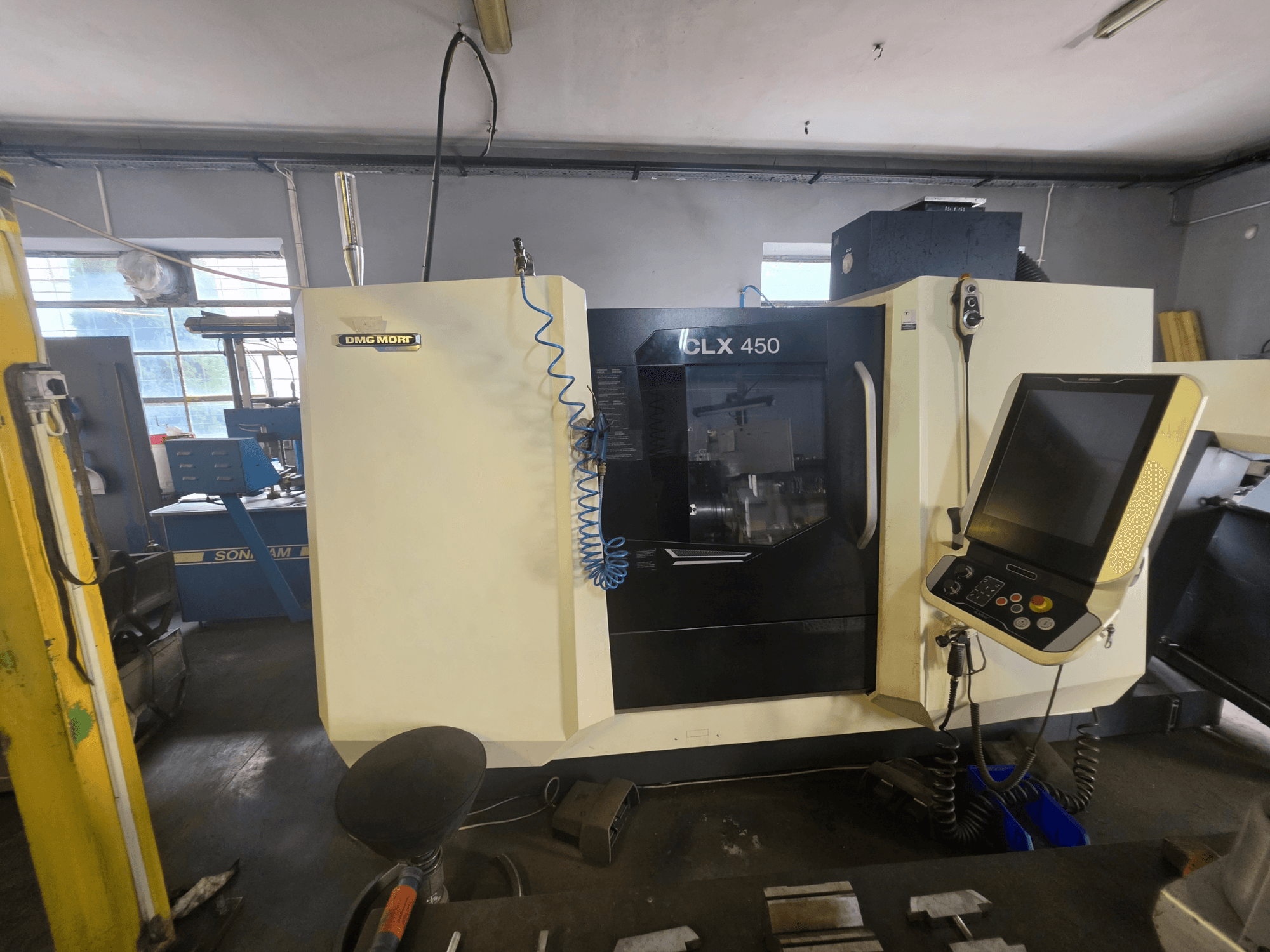 A DMG MORI CLX 450 V6 vízszintes eszterga elölnézetben, a vezérlőpanellel és a jól látható márkajelzéssel.