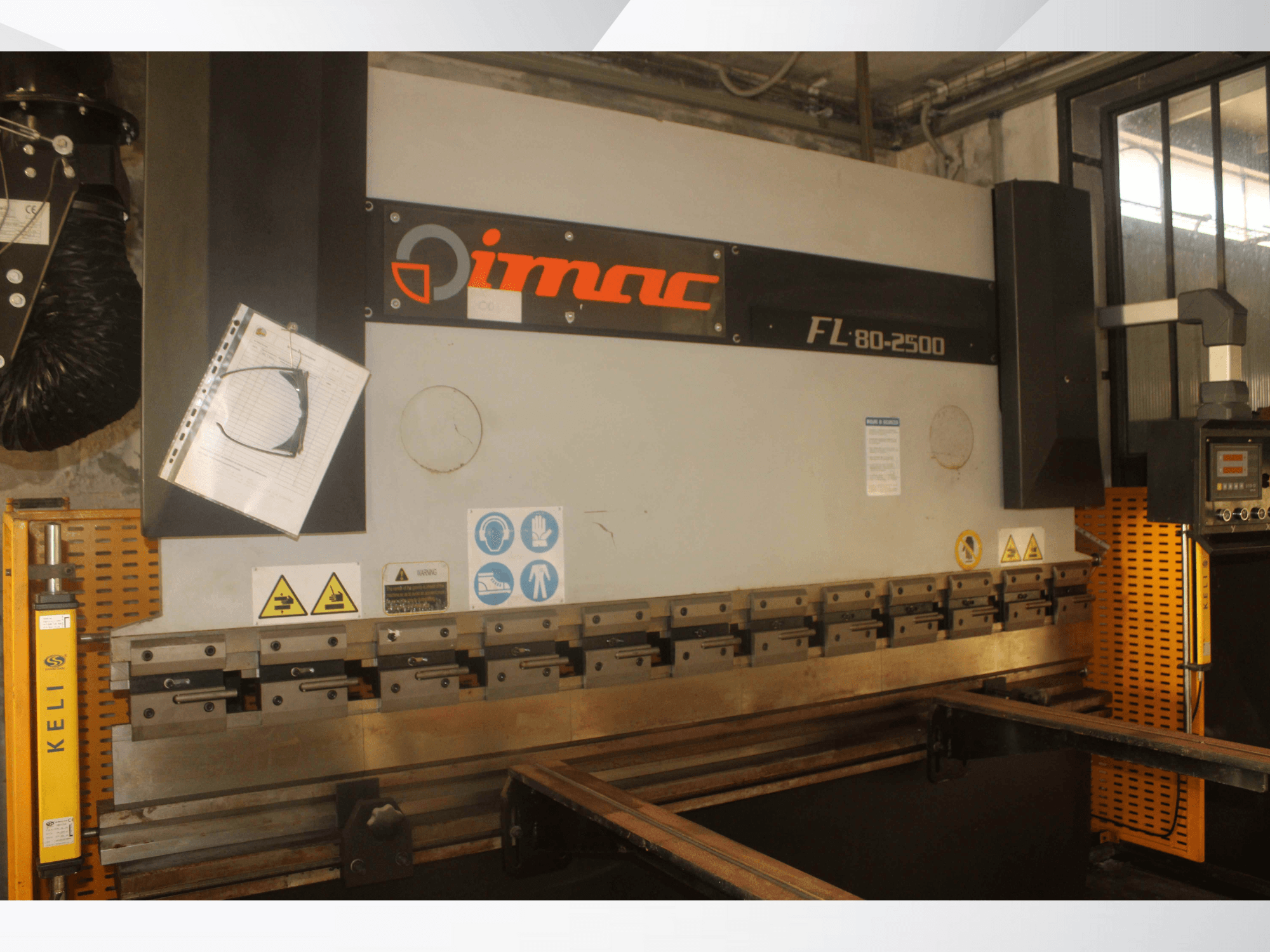 IMAC FL 80-2500 hajlítógép, előlnézet, vezérlőpanel, biztonsági figyelmeztetések és fém szerszámelemek.