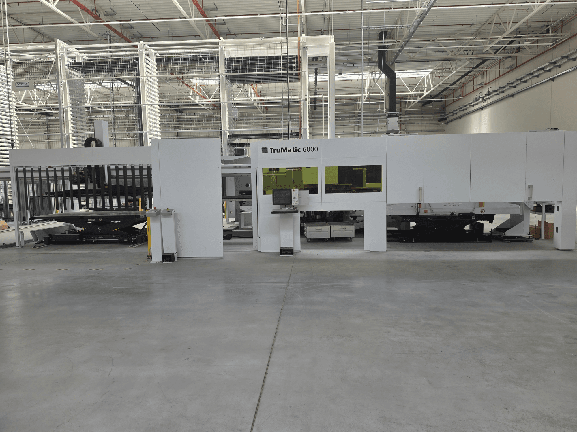 TRUMPF TruMatic 6000 automatizált lemezmegmunkáló rendszer, elölnézet, a vezérlőpanellel és a betöltőterülettel.