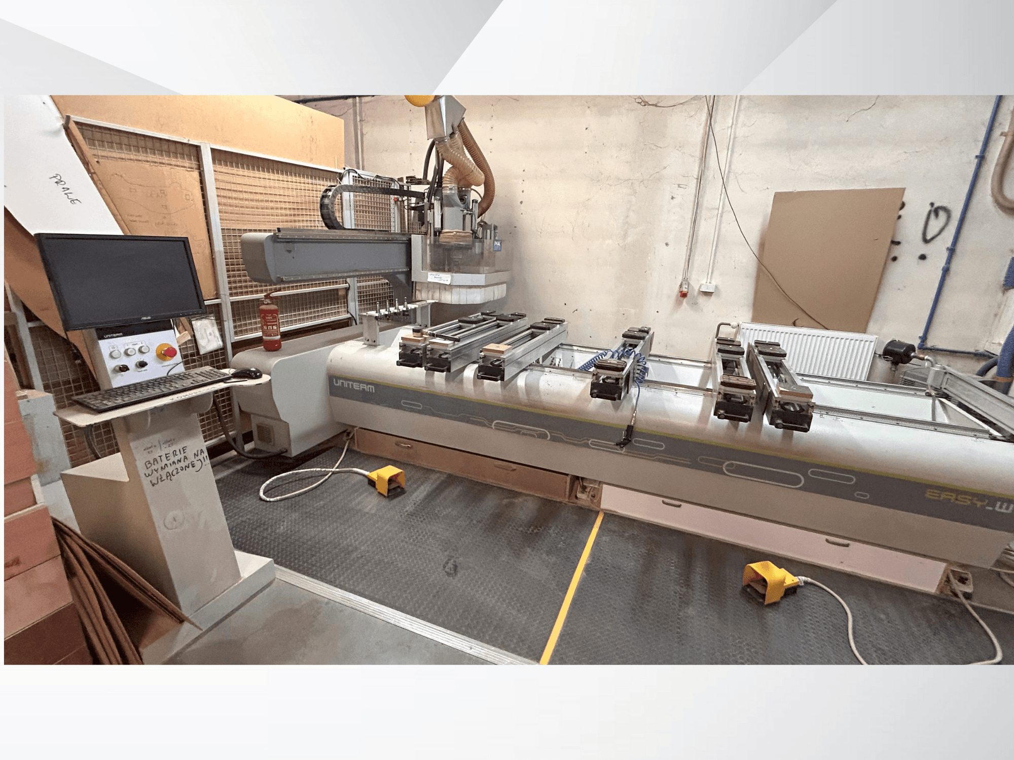 Egy UNITEM EASY-W CNC-gép elülső nézete, a kezelőpanellel, a monitorral és a munkaasztalon rögzített munkadarabokkal.